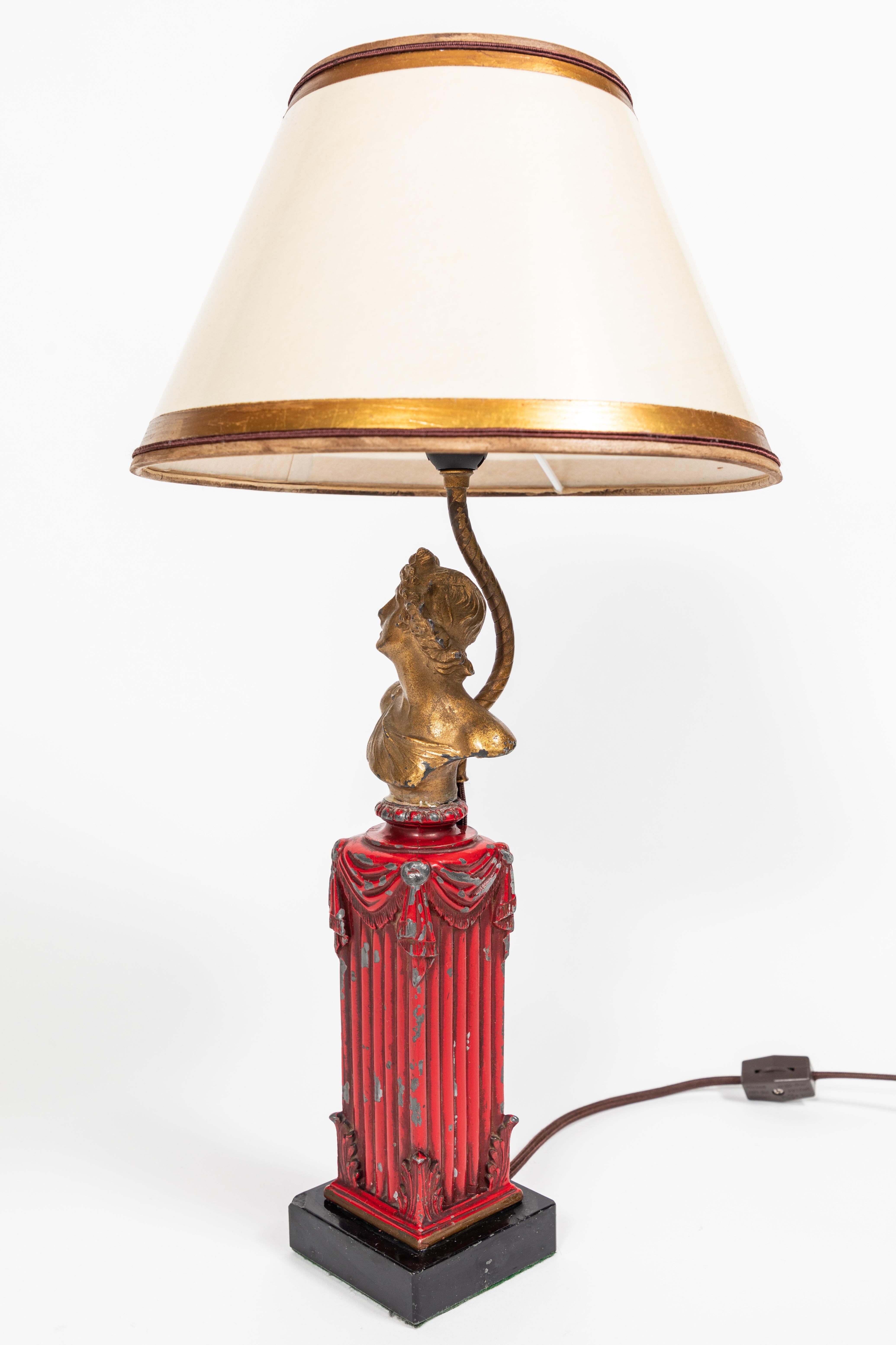 Small vintage metal table lamp with black marble base. Squared column base is topped with a bust of Greek man, has original red and gold cold paint application and has been newly rewired.

Includes beautiful new custom shade of oiled parchment