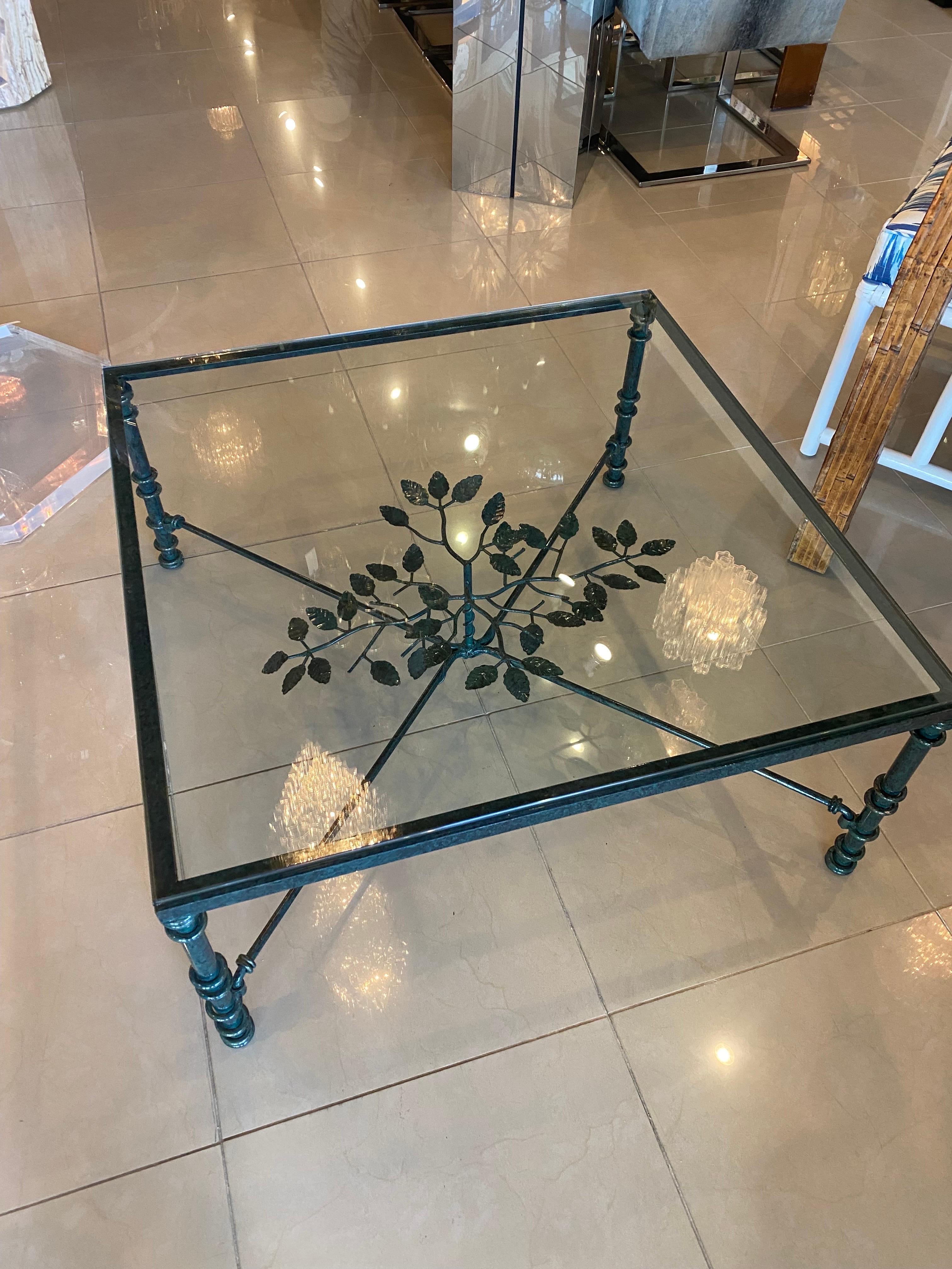 Vintage metal coffee table with glass top. One small knick on corner of glass, pictured. The finish is a malachite/verdi gras look with black and green colors, which is original to the table. Leaves in middle under the glass. In the style of