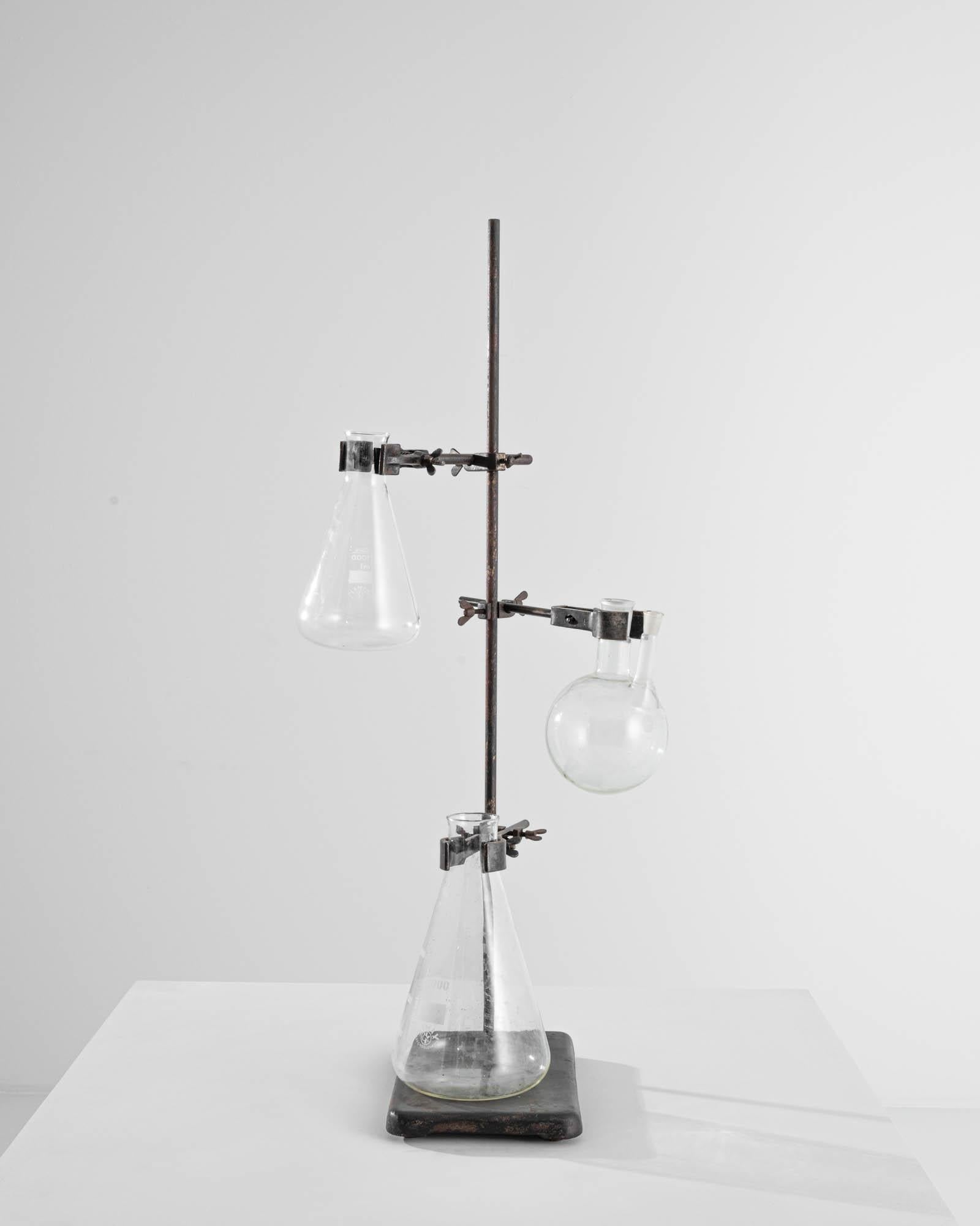 An intriguing and unique accent, this vintage lab-ware stand holds various vintage technical glasswares. Industrial, utilitarian, and scientific, yet also playful and curious, this vintage beaker holder presents a unique demeanor. Born for the
