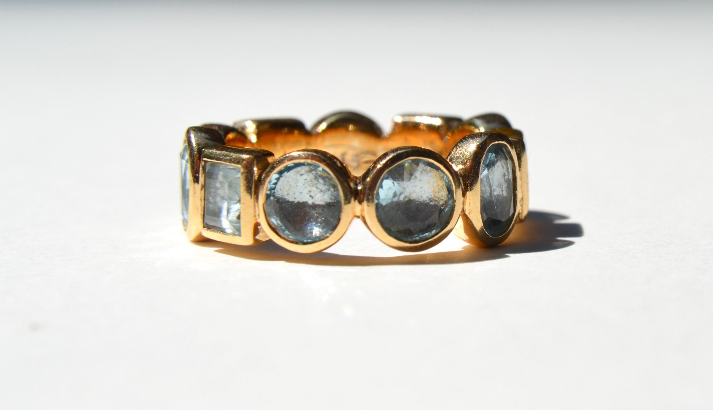 

Gorgeous vintage c1990s Metropolitan Museum of Art NYC ancient Roman reproduction blue topaz 14K yellow gold eternity band ring. In excellent condition. Size 6, cannot be resized. Three different stone cuts make up this eternity band: oval (6x4mm