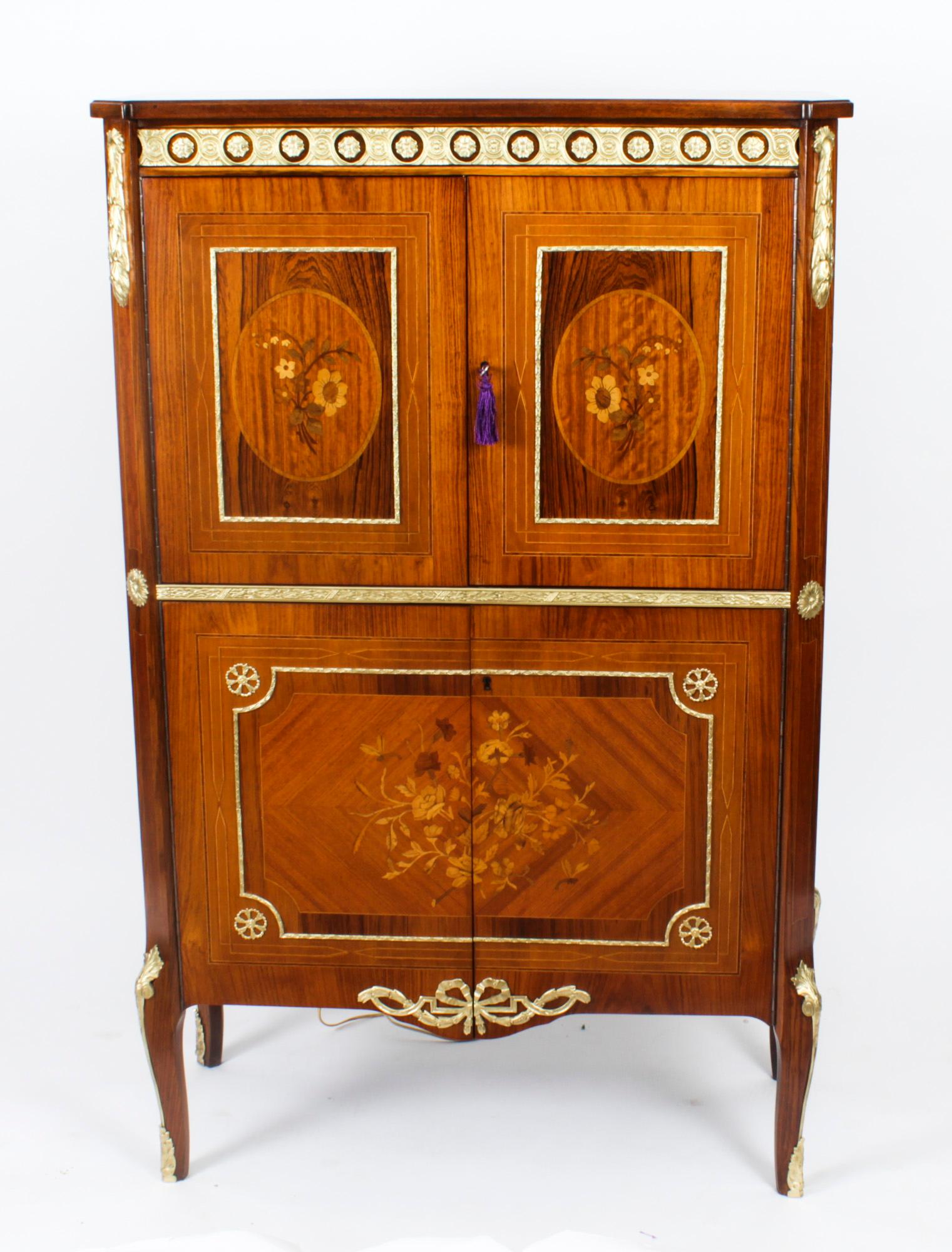 This is a stupendous vintage Meuble Francais Empire Revival burr walnut and ormolu mounted cocktail cabinet with fitted and mirrored interior, of the highest quality and dating from Circa 1970.

The upper part comprises a pair of doors that each