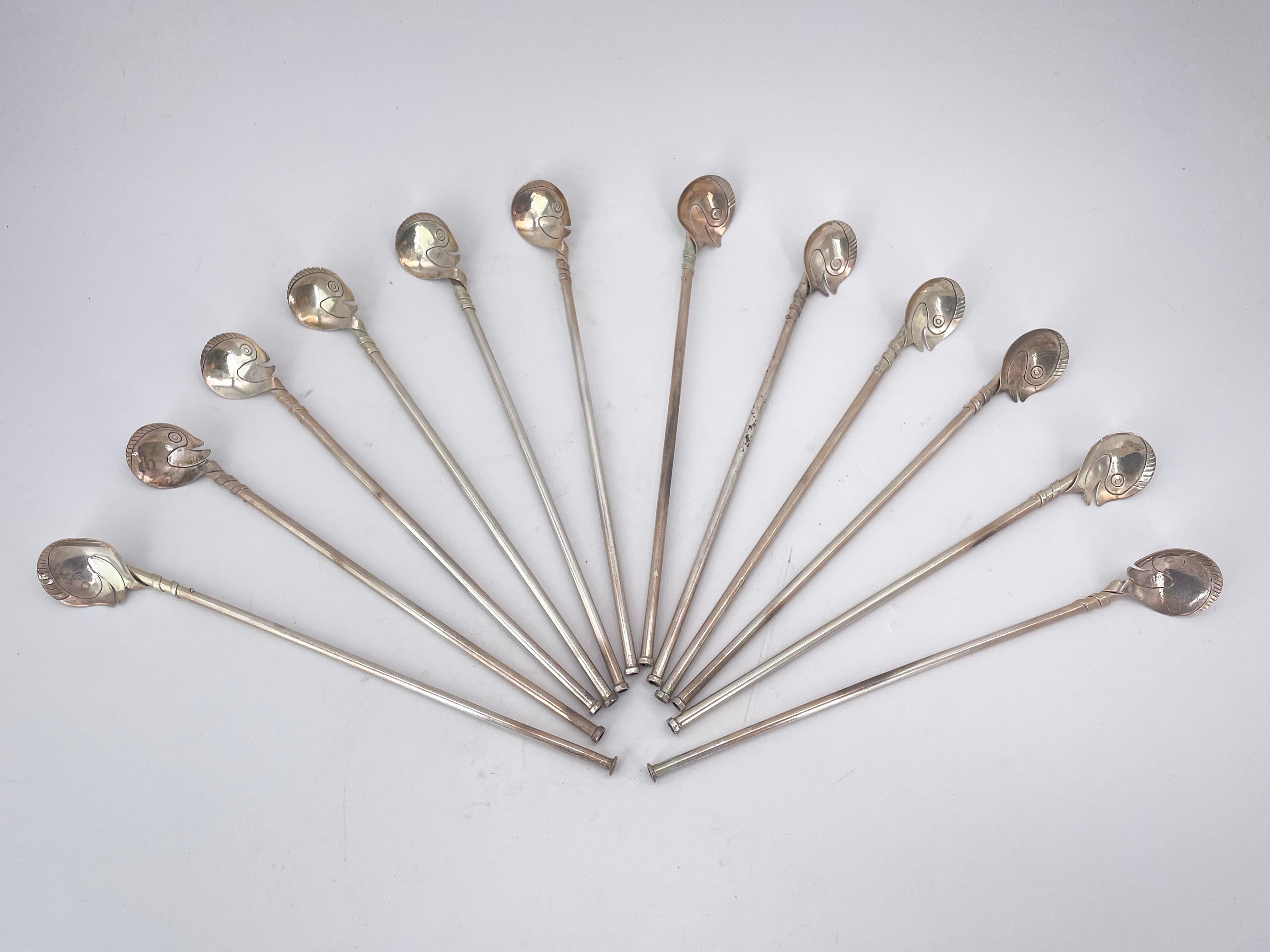 Ce magnifique ensemble de 12 pailles en argent sterling vintage du milieu du siècle. Fabriquées au Mexique par Taxco, ces pailles présentent des têtes de cygne abstraites avec des plumes de queue découpées qui s'enroulent autour des pailles pour