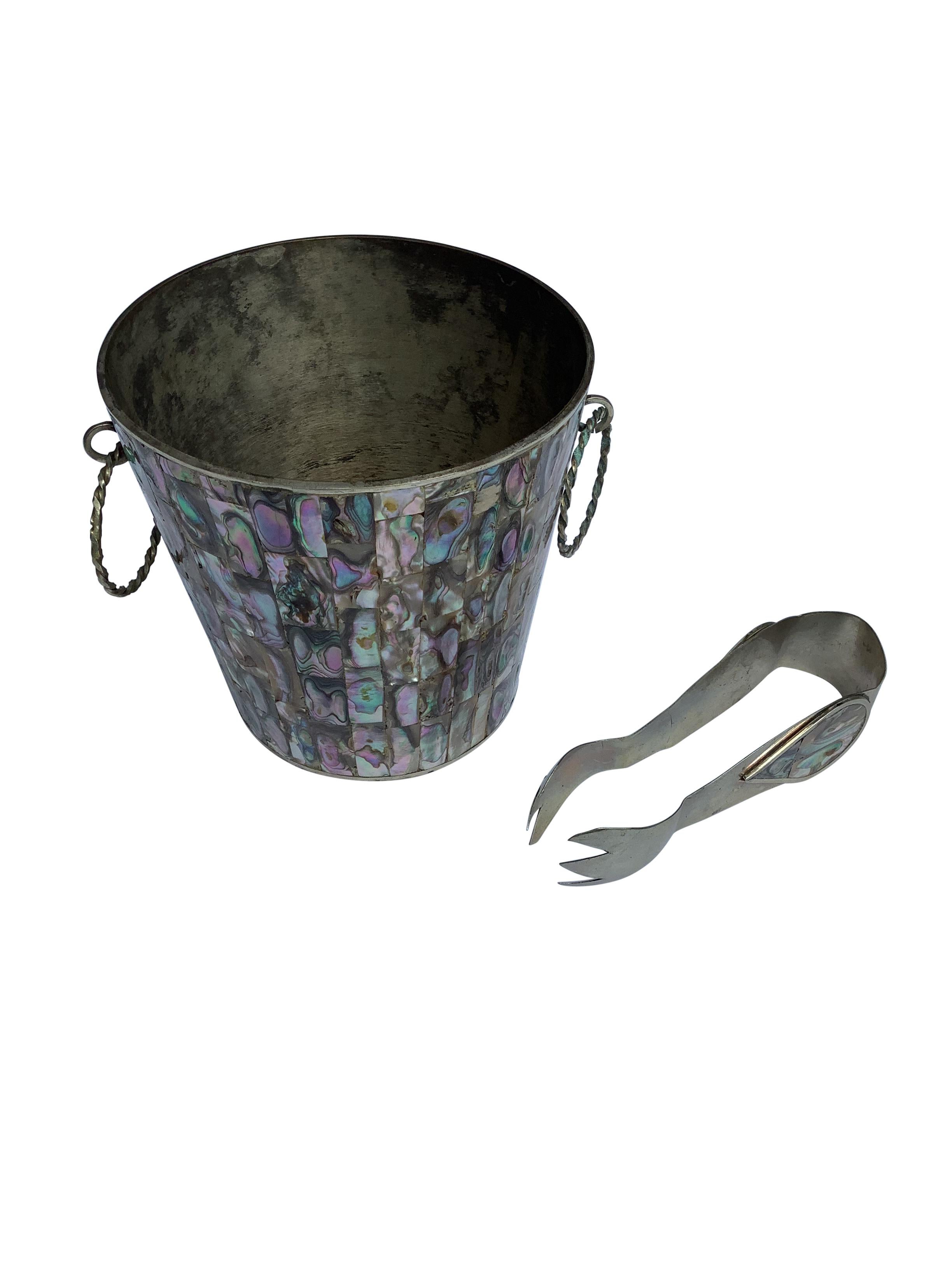 Vintage Mexican Abalone and Alpaca Silver Ice Bucket and Tongs with twisted ring handles. Colorful individual tiles of abalone adorn the metal bucket. Stamped on bottom Alpaca Mexico.
