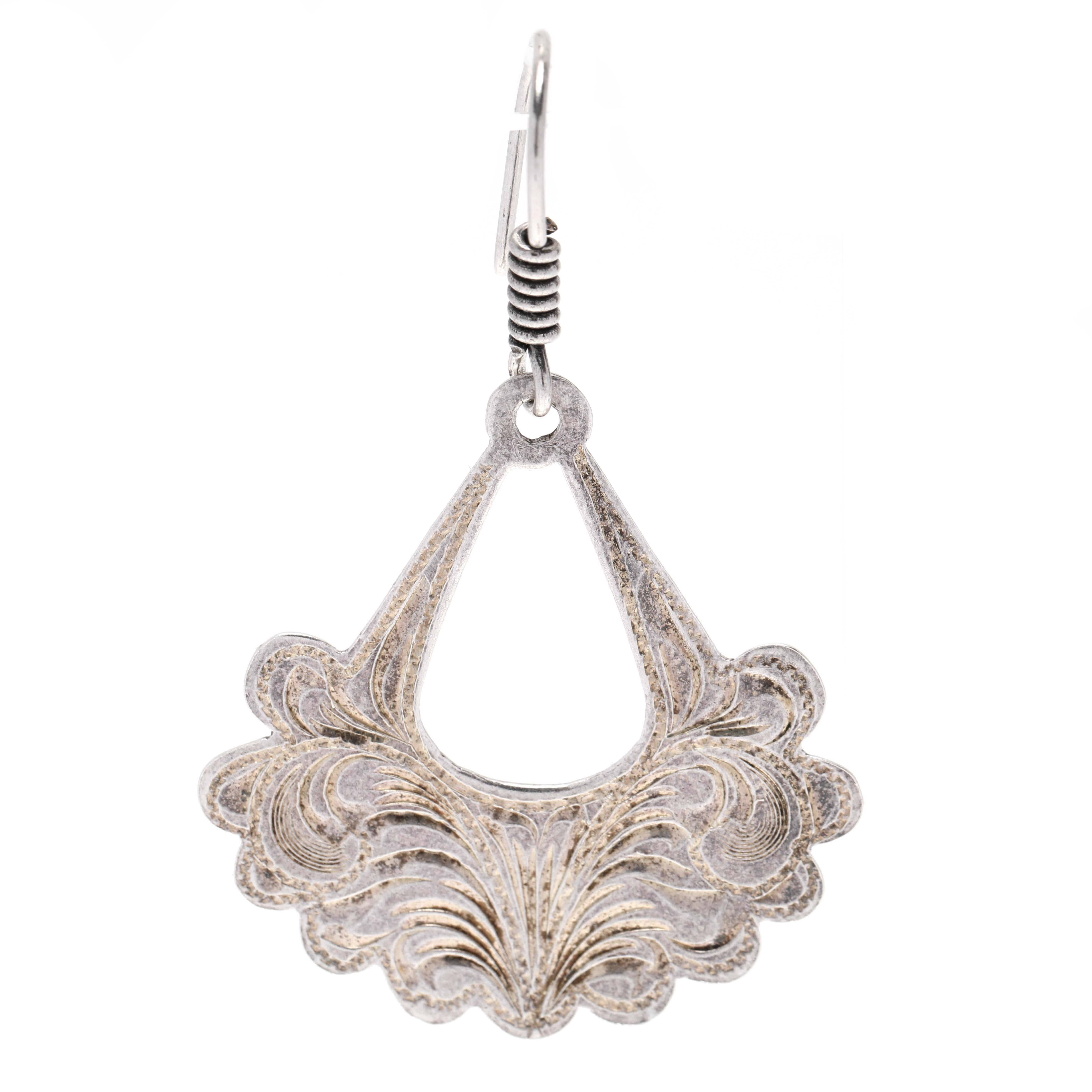 These one-of-a-kind Vintage Mexican Engraved Scroll Dangle Earrings are the perfect statement piece for any outfit. Crafted of sterling silver, these eye-catching earrings measure 2 1/8 inches in length and feature intricate, hand-engraved details.