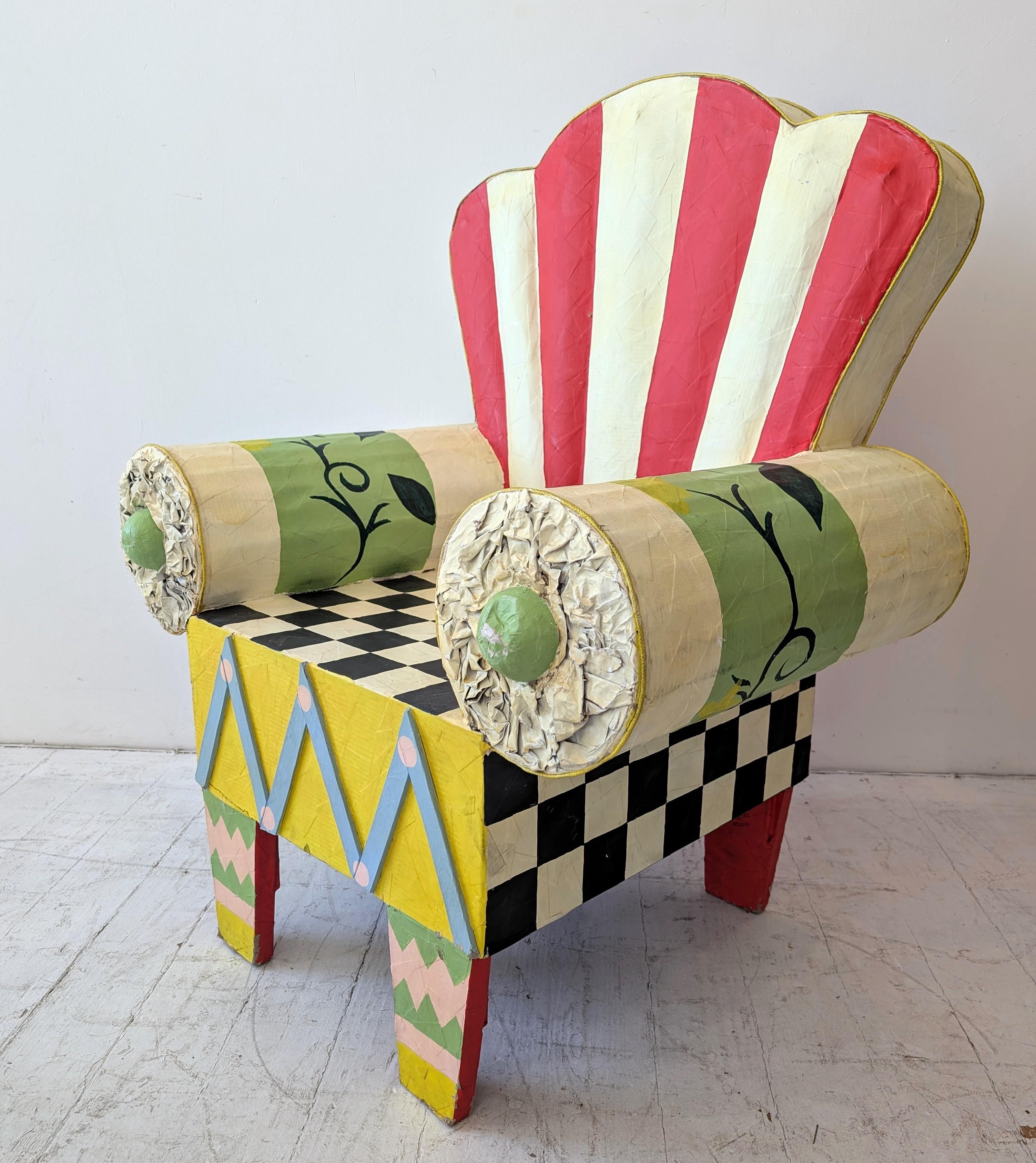 A unique, full size paper mache 1980s armchair, signed G.Dell, Mexico. Charmingly naive paintwork.
An amazing combination of Memphis Milano and circus big top pattern and colour: buy it if you want a chair no-one else has.
It is strong enough to sit