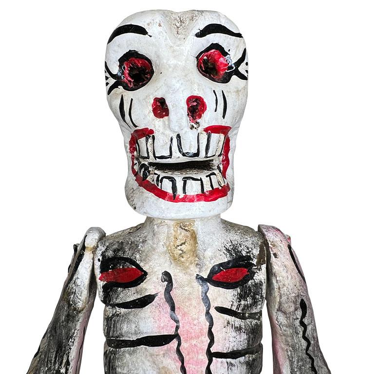 Esta rara estatuilla mexicana vintage de esqueleto articulado hecho a mano es un asombroso ejemplo de arte popular tradicional. Tallada con maestría en madera, esta pieza refleja la vibrante cultura y el arte de México. El esqueleto está