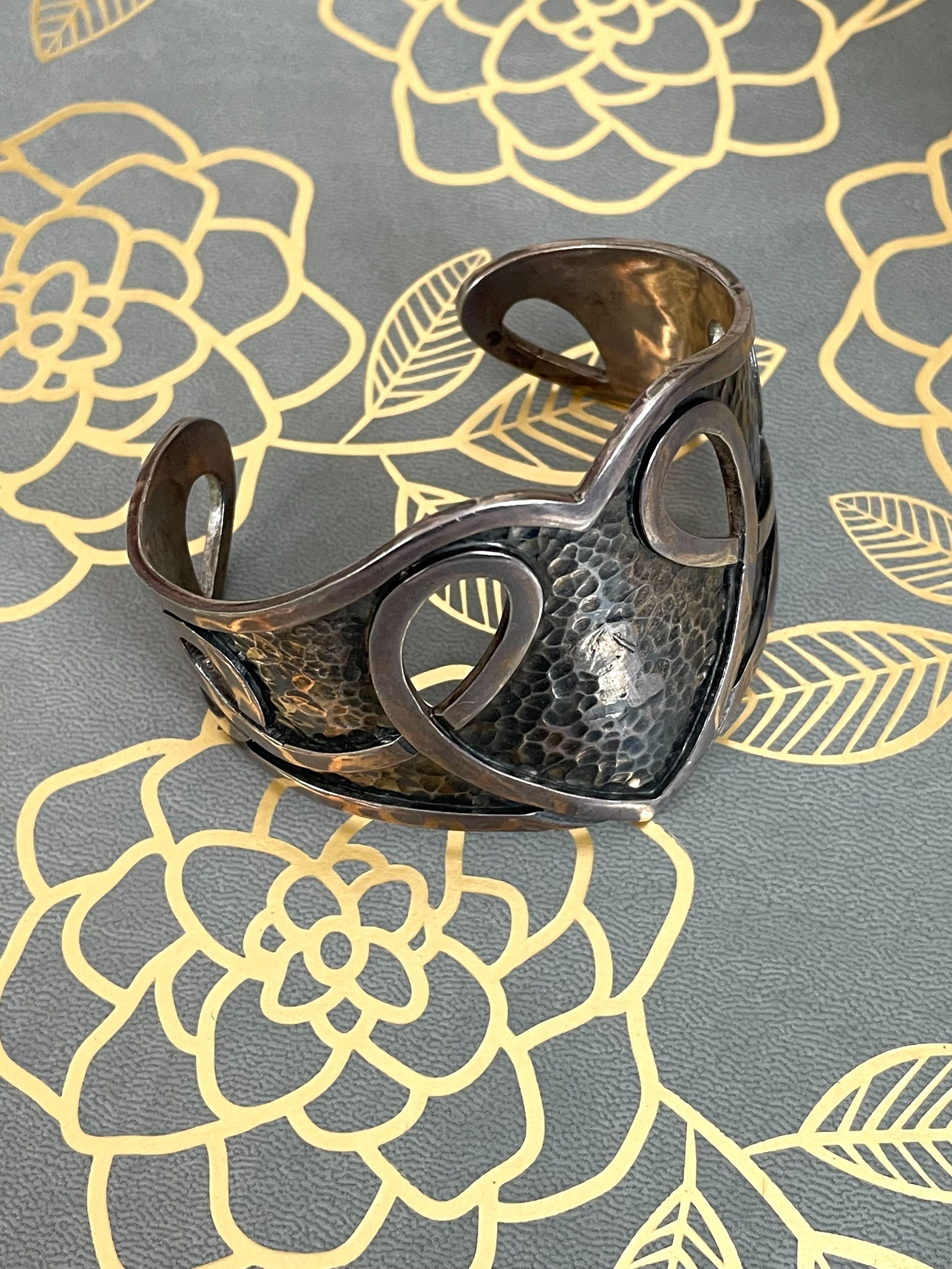 Dieses klassische Manschettenarmband von Margot de Taxco aus Sterlingsilber zeichnet sich durch ein schönes herzförmiges Design in der Mitte der Manschette aus.

Stempel: MARGOT DE TAXCO 5195 MADE IN MEXICO STERLING

Abmessungen:
Außenseite: