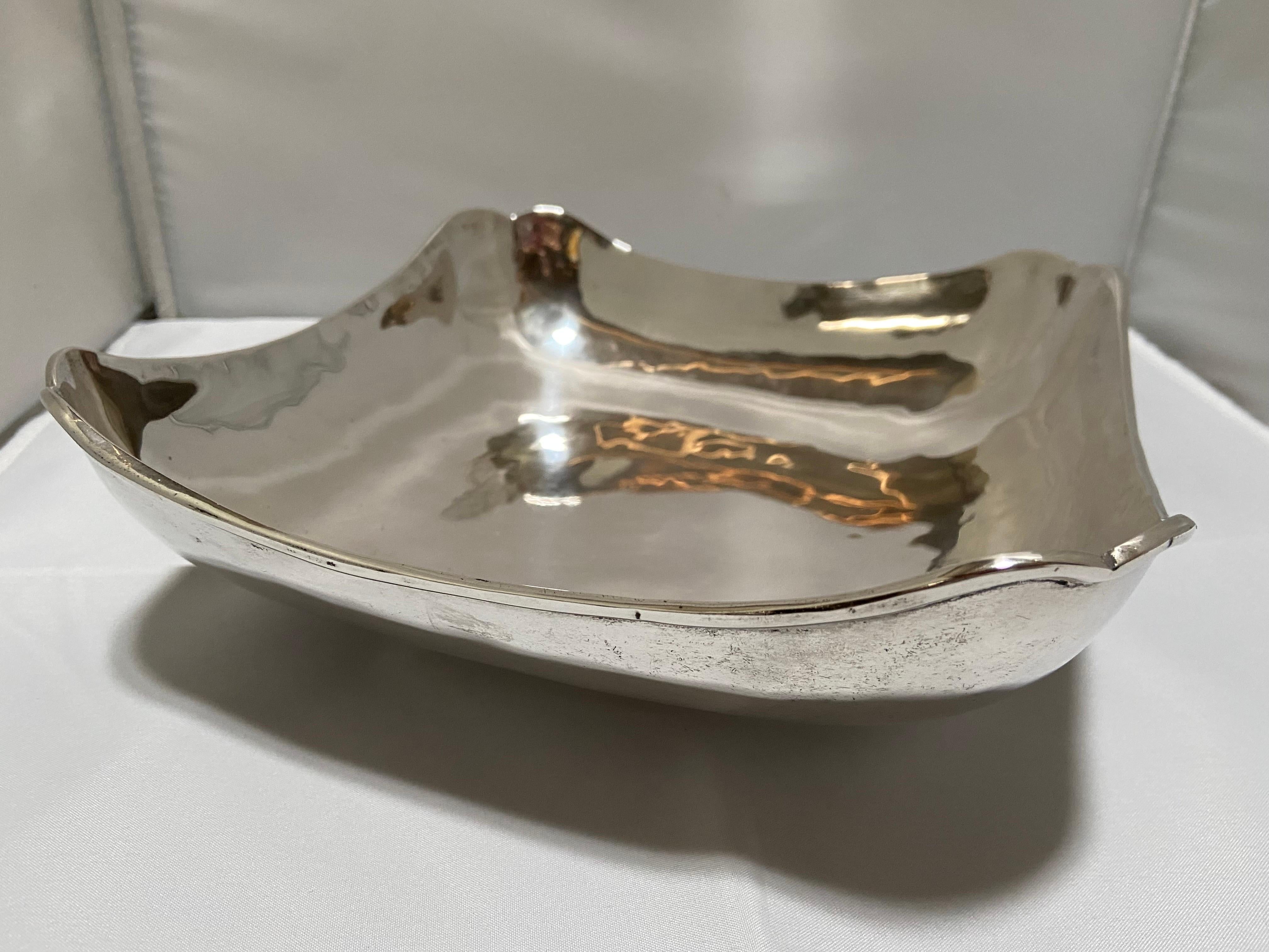A vintage Mexican sterling silver bowl by the maker C. Zurita. With a nod to the eponymous design firm, Georg Jensen, this piece exhibits a bold, Modernist style with a wide, low profile, scalloped corners and a banded foot. Marked on the bottom.