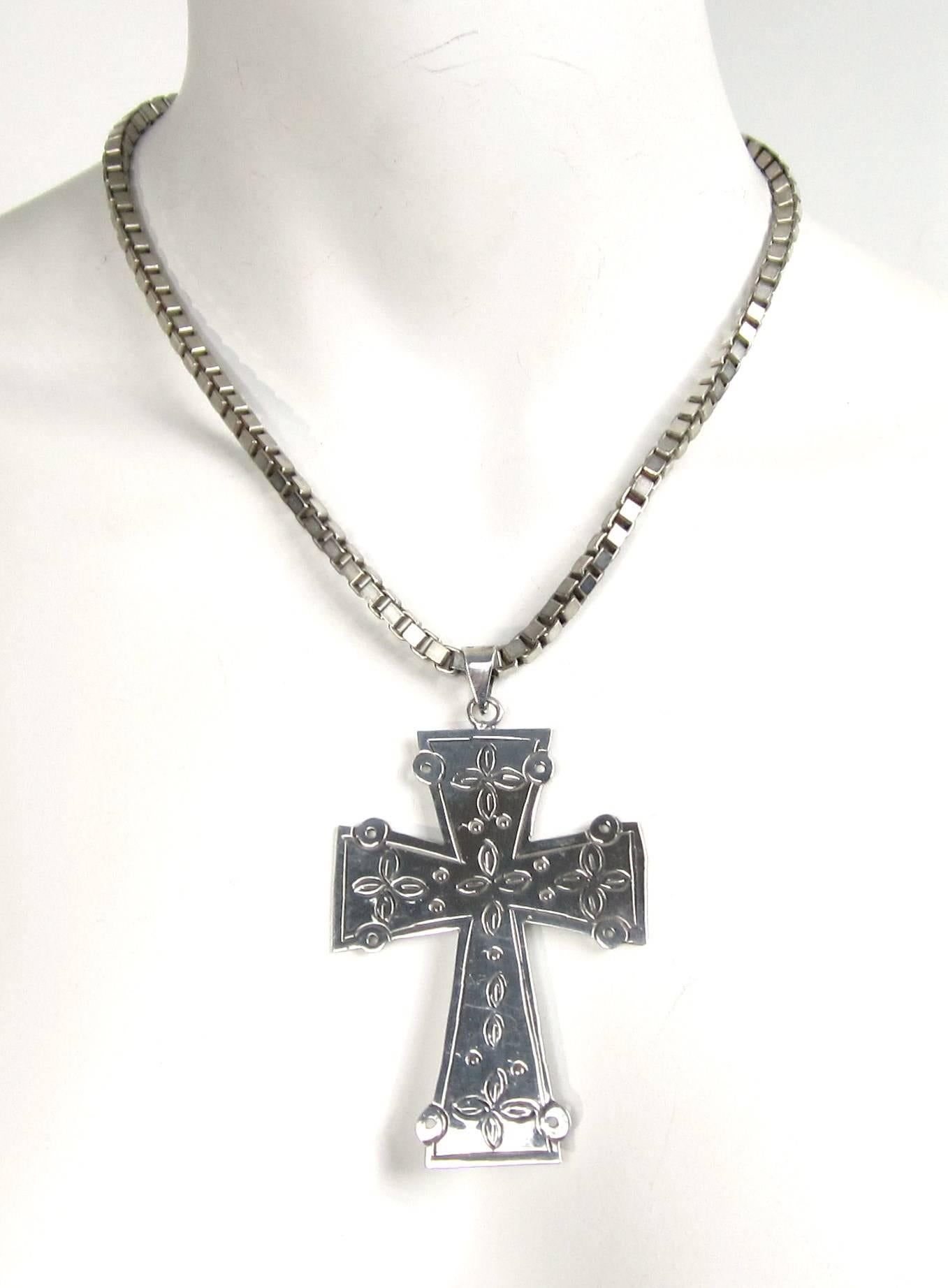 This is a large sterling silver cross with wonderful cut outs. Hallmarked on the back- Measures 2.95 inches  x 2.13 inches. There is a large bale to accommodate a large chain. Attached is a large Sterling Silver box Chain measuring 18.25 inches end