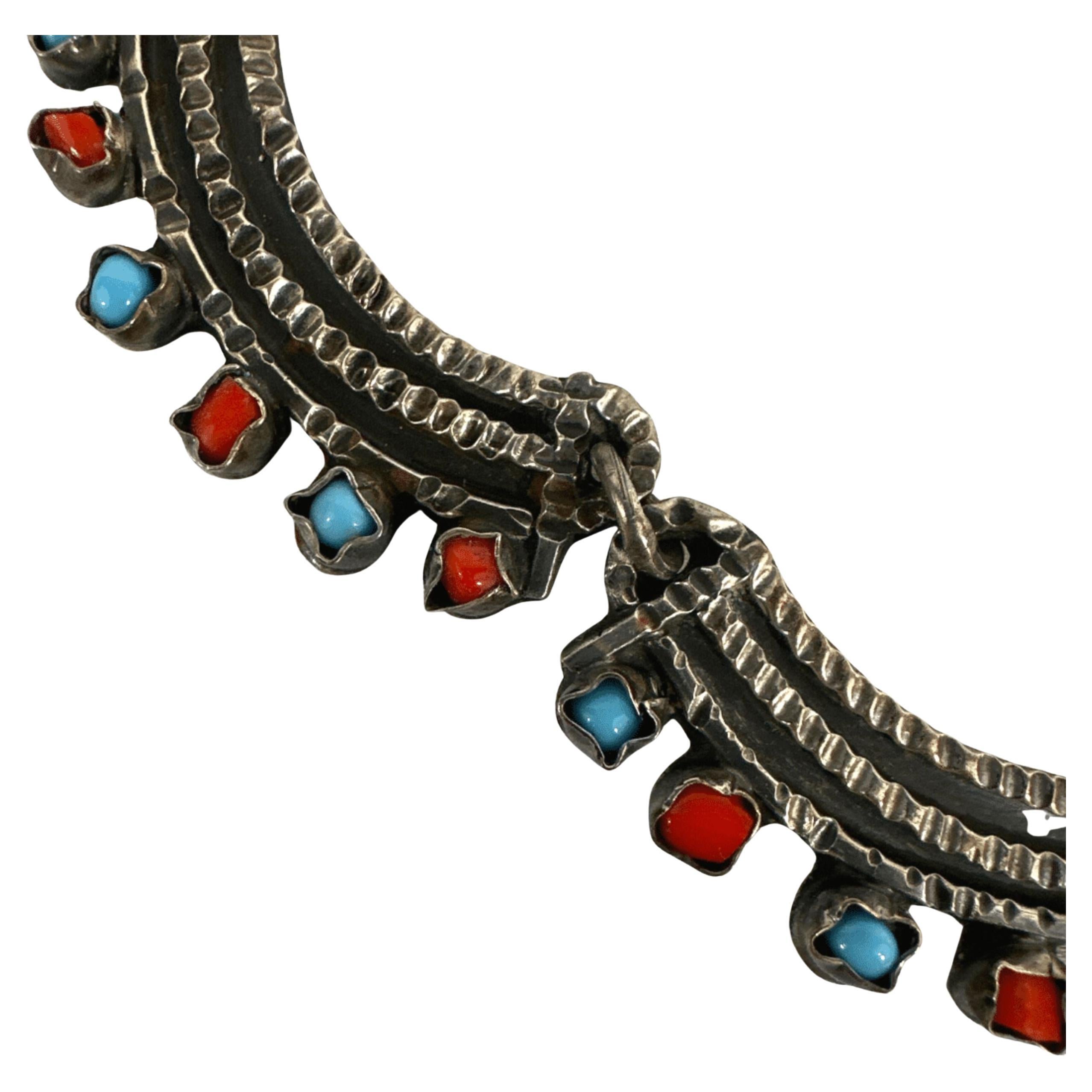 Un capolavoro dell'argenteria messicana
Questa collana vintage in argento sterling è un esempio straordinario di artigianato messicano, caratterizzato da una lavorazione artigianale dell'argento con vivaci intarsi di turchesi e pietre rosse.