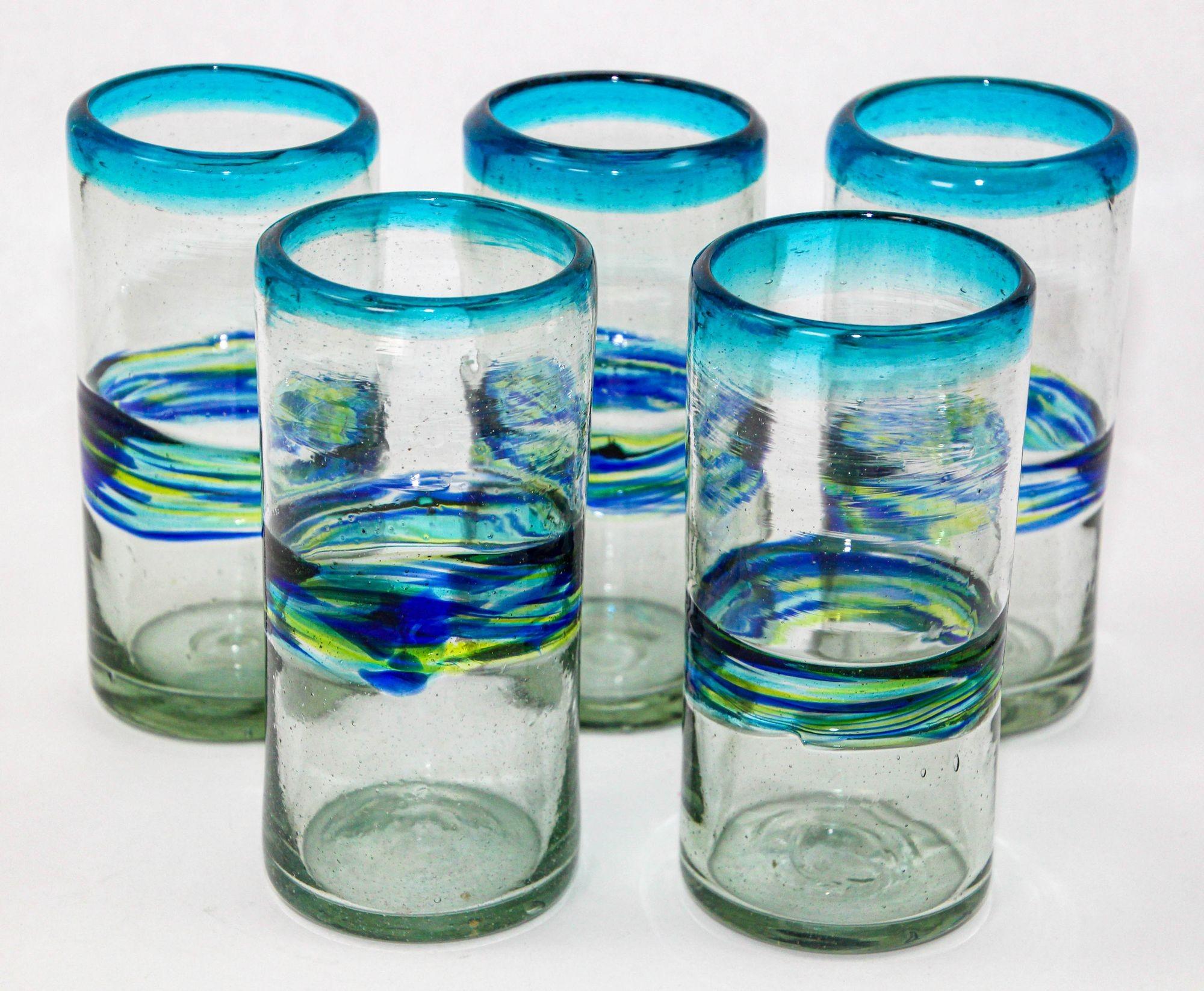 Set of 5 hand-blown vintage tumblers, each a testament to the skill of Mexican glass artists.
These glasses boast a mesmerizing blue and green swirl band, setting the stage for a unique and stylish addition to your barware collection.
Hand-crafted