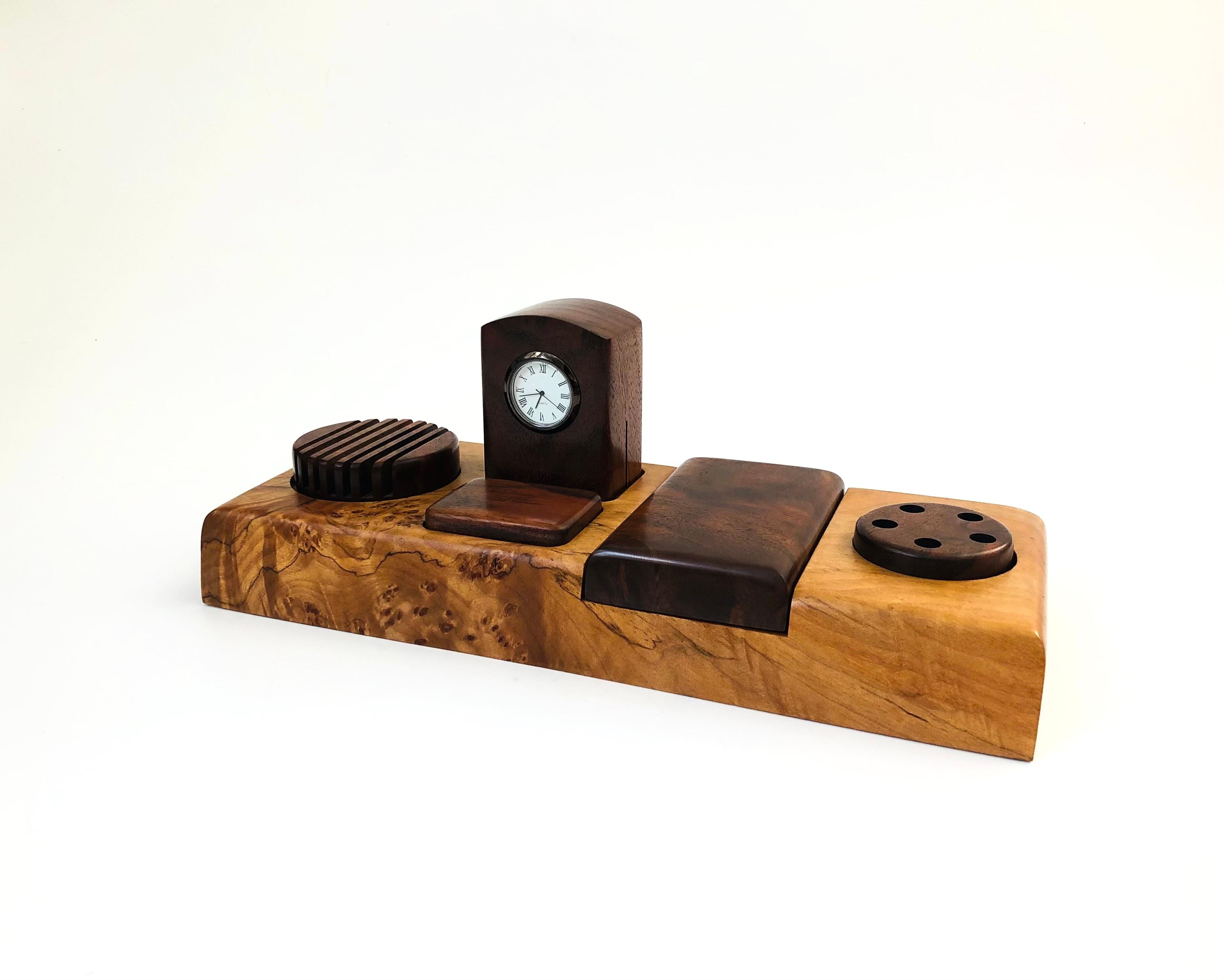 A beautiful vintage carved wood valet by Michael Elkan Studio. Walnut toned wood components nest neatly into a lighter toned burlwood base. Features circular letter and pen holders on each side. In the center is a small storage compartment for