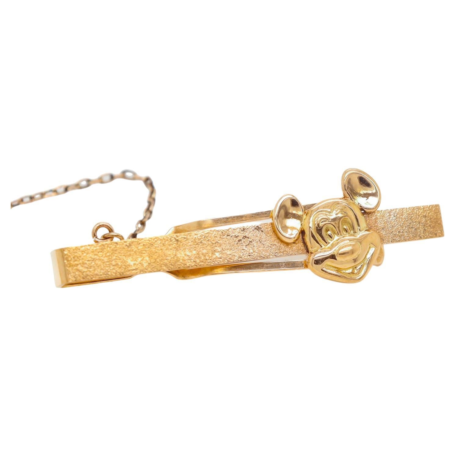 A fine vintage Mickey Mouse tie bar.

In 14k gold.

With a front with a stippled finish and mounted with a 3-dimensional head of Mickey Mouse.

Set with a button safety ring.

Marked to the reverse for Walt Disney Productions.

Simply a wonderful