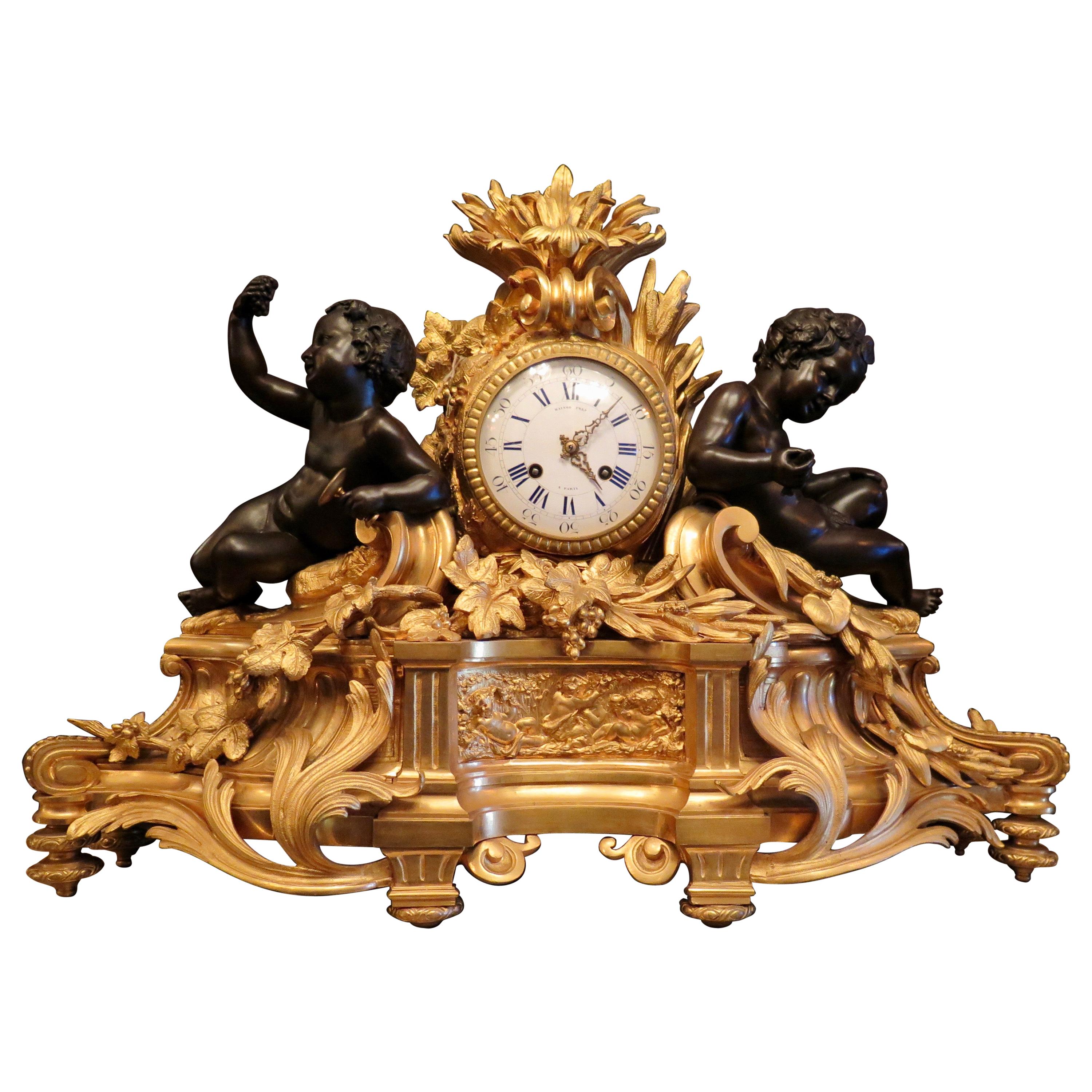 Cette horloge de garniture française vintage du milieu du 19e siècle, composée de 3 pièces, est merveilleusement conçue dans le style Louis XVI. L'ensemble surdimensionné comprend une horloge exceptionnelle en bronze doré accentuée par des figures