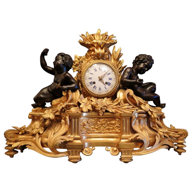 This vintage mid-19th century French 3-piece garniture clock set is wonderfully designed in the Louis XVI style. The over size set includes an exceptional gilt bronze clock accented with attached detailed patinated sculpted putti figures on both