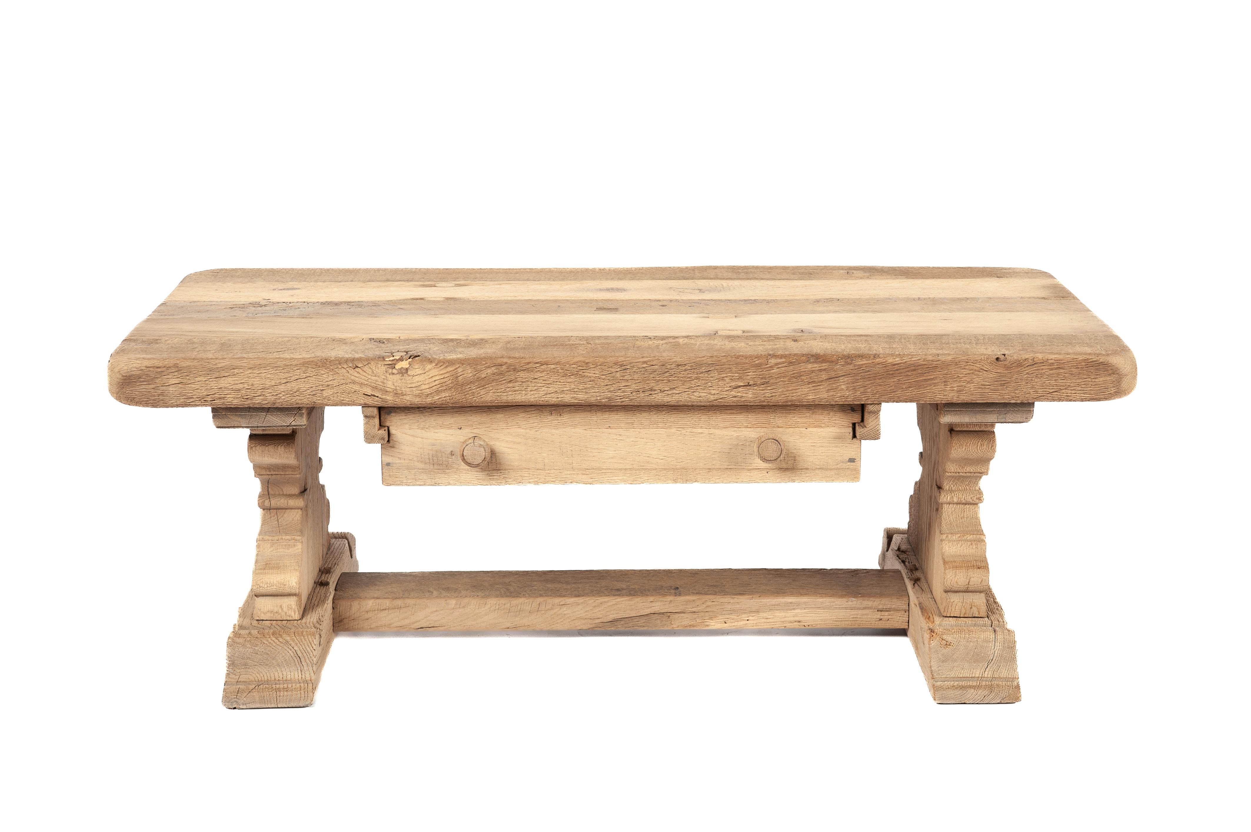 On offer here is a beautiful vintage coffee table, meticulously crafted from reclaimed oak wood dating back to the 1960s. This rustic piece was built by the esteemed Piet Rombouts & Sons furniture workshop, a legacy proudly continued by our family.
