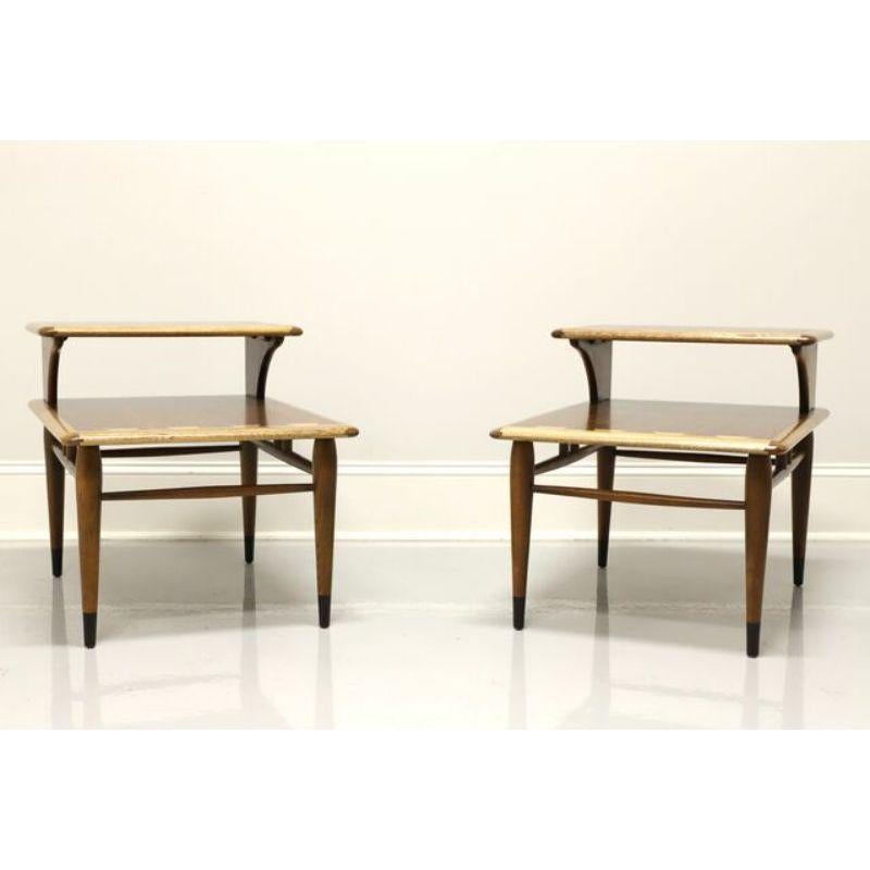 A pair of rectangular shaped Mid-Century Modern style step end tables by Lane, their Acclaim Series designed by Andre Bus. Walnut with lighter stained dovetail design to step tops, stretcher base, tapered round legs and black painted feet. Made in