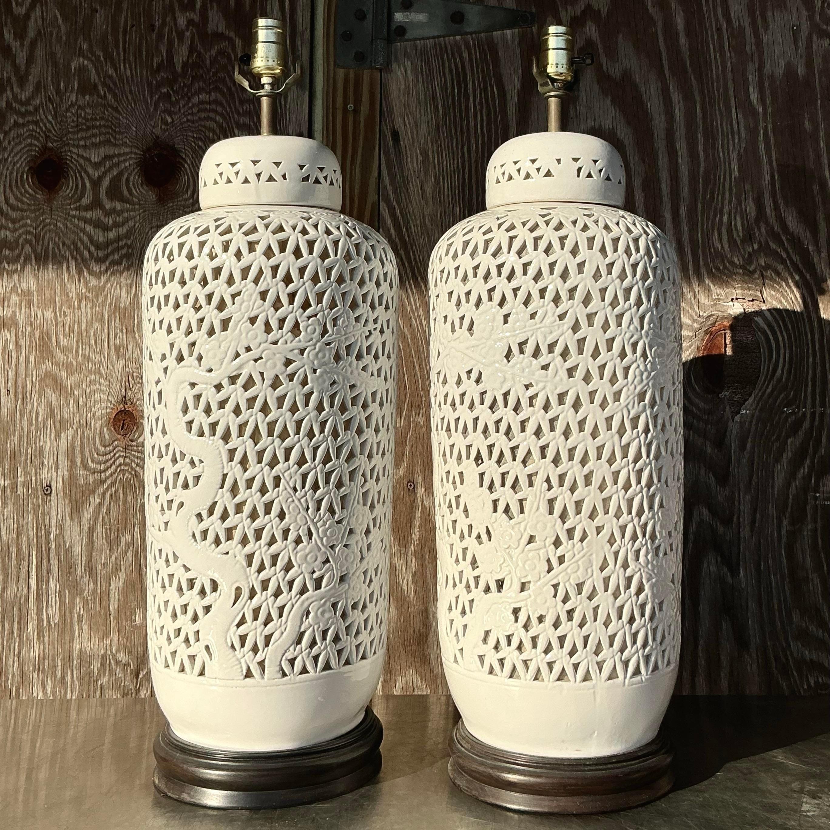 Illuminate your space with timeless elegance with this pair of Vintage Asian monumental Mid-Century Modern Blanc De Chine Pierced Ceramic Lamps. Featuring intricate pierced patterns and a smooth blanc de chine (white porcelain) finish, these lamps