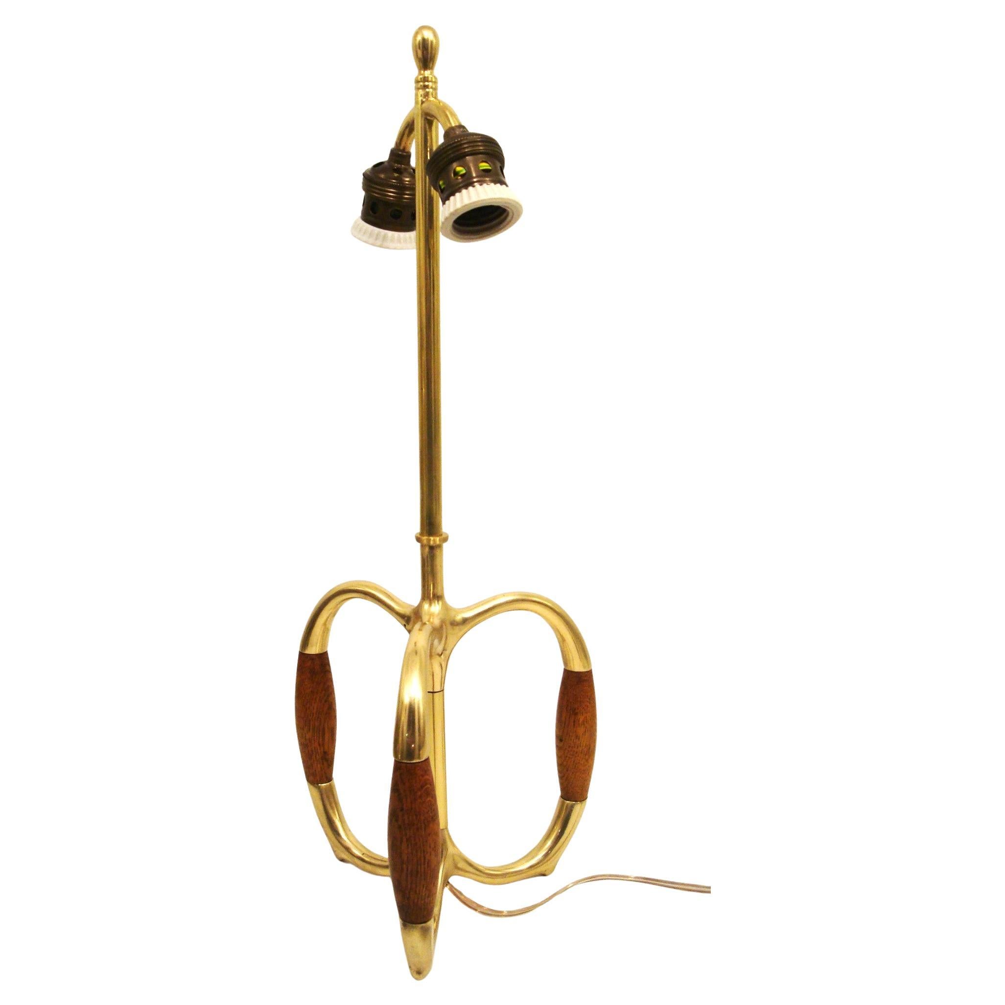Vintage Mid-20th Century Brass and Oak Wood Table Lamp. 1960´s

Vintage lamp with a unique design. The lamp has a brass body with wooden accents on the base. The base is tripod-like, with three curved legs that have wooden grips. The lamp has two