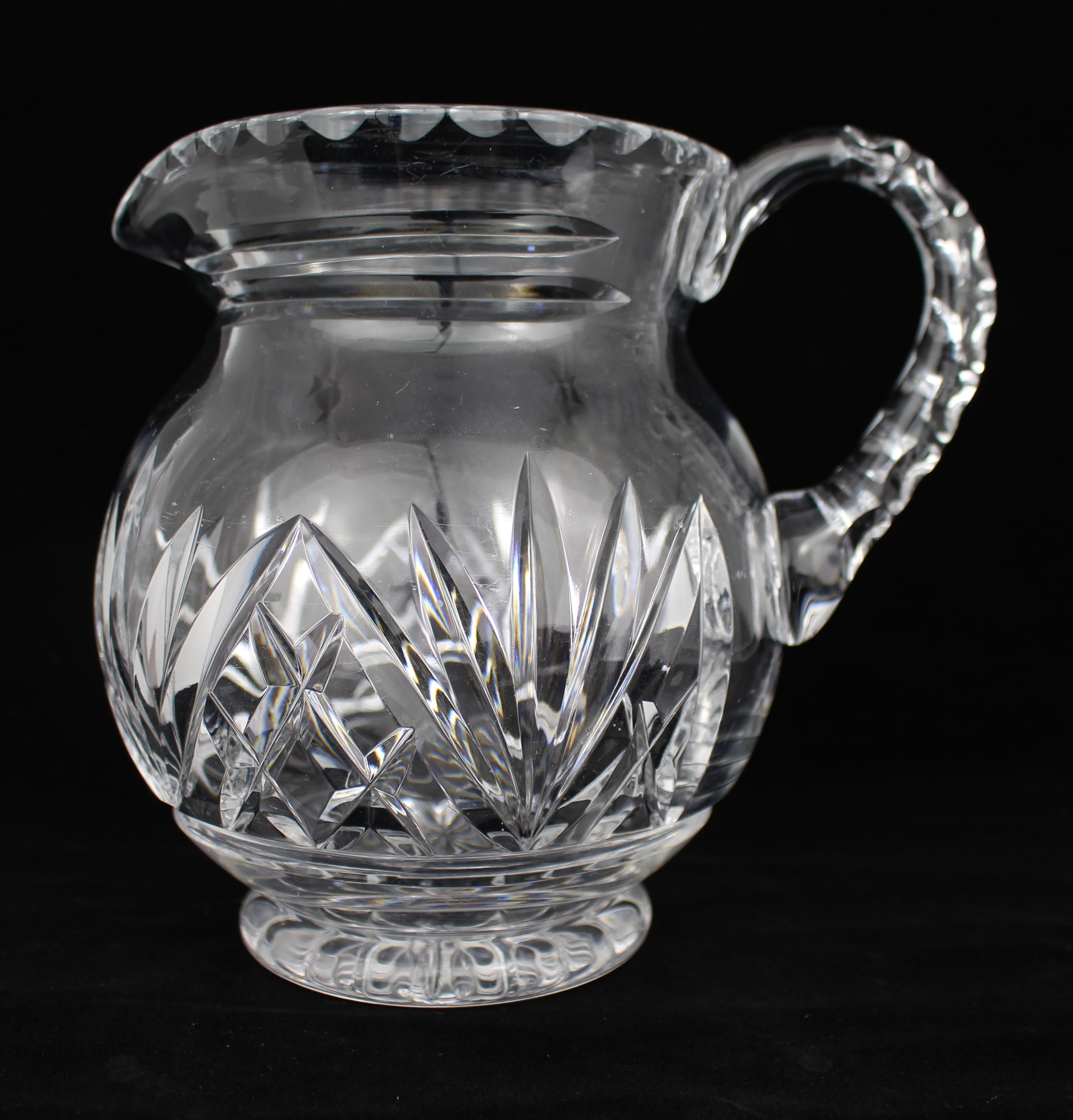Vintage Mid-20th Century Cut Glass Crystal Jug


A fine vintage cut glass crystal jug, dating from the mid-20th century. Of rounded bulbous form, the jug features a scalloped rim, a deeply faceted handle, and a star-cut base. The body is decorated