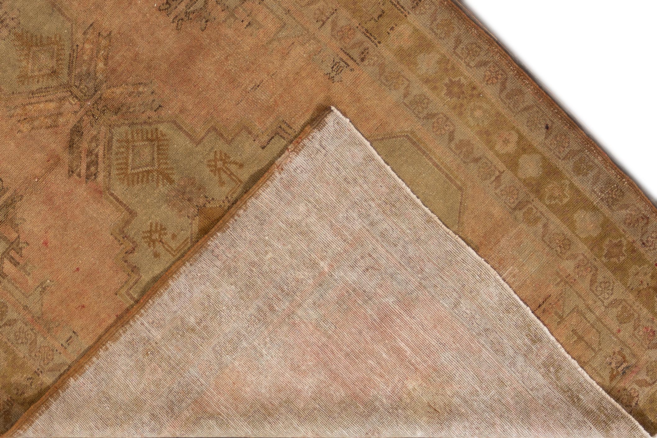 Es handelt sich um einen handgeknüpften Khotan-Teppich aus der Mitte des 20. Jahrhunderts mit beiger Farbe und floralem Medaillonmuster. Der Teppich misst 5'3