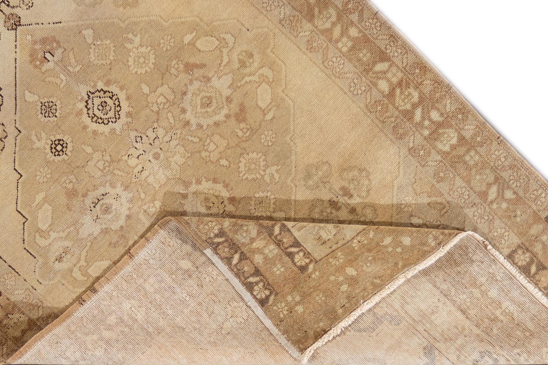 This is a mid-20th century hand knotted Khotan rug with a beige color and medallion geometric design. The rug measures 4'8