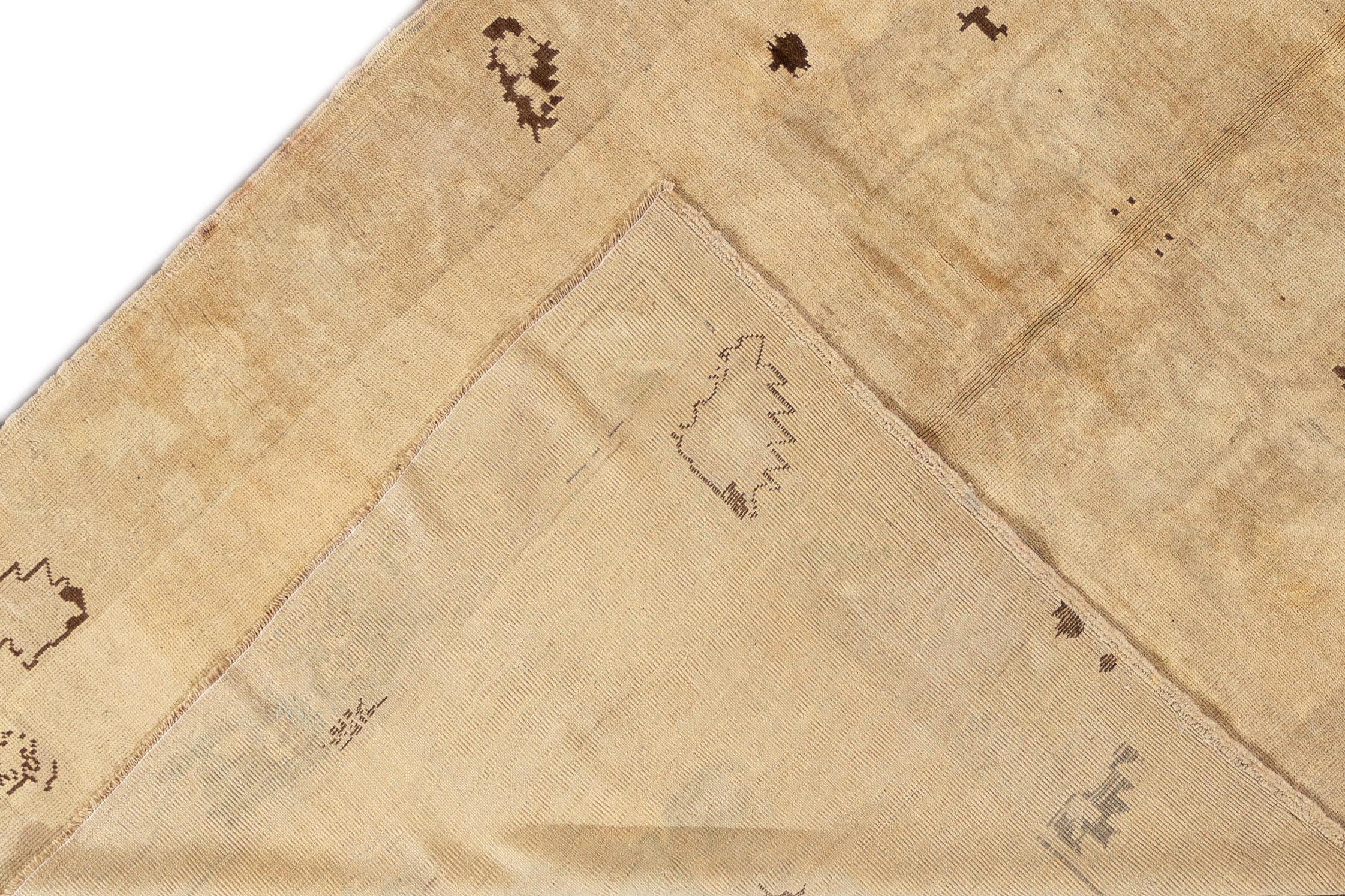Il s'agit d'un tapis Khotan du milieu du 20e siècle, noué à la main, de couleur beige, avec un motif sur toute la surface. Le tapis mesure 5'9