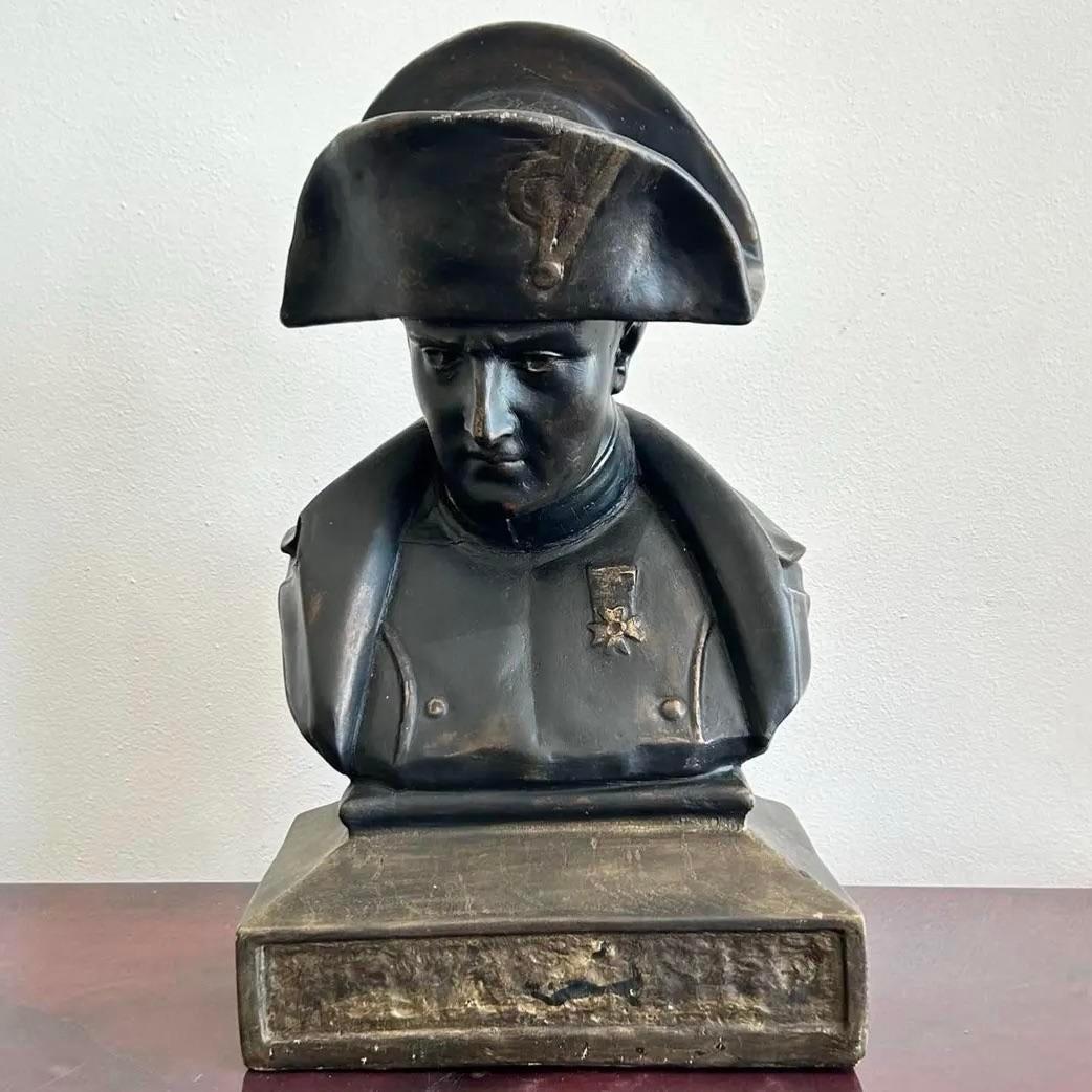 Questo busto di Napoleone, in bronzo, attira l'attenzione con uno sguardo pesante e una silhouette inconfondibile. Il suo iconico cappello a bicorne e il suo cappotto militare sono resi con linee audaci e semplificate che enfatizzano la forma