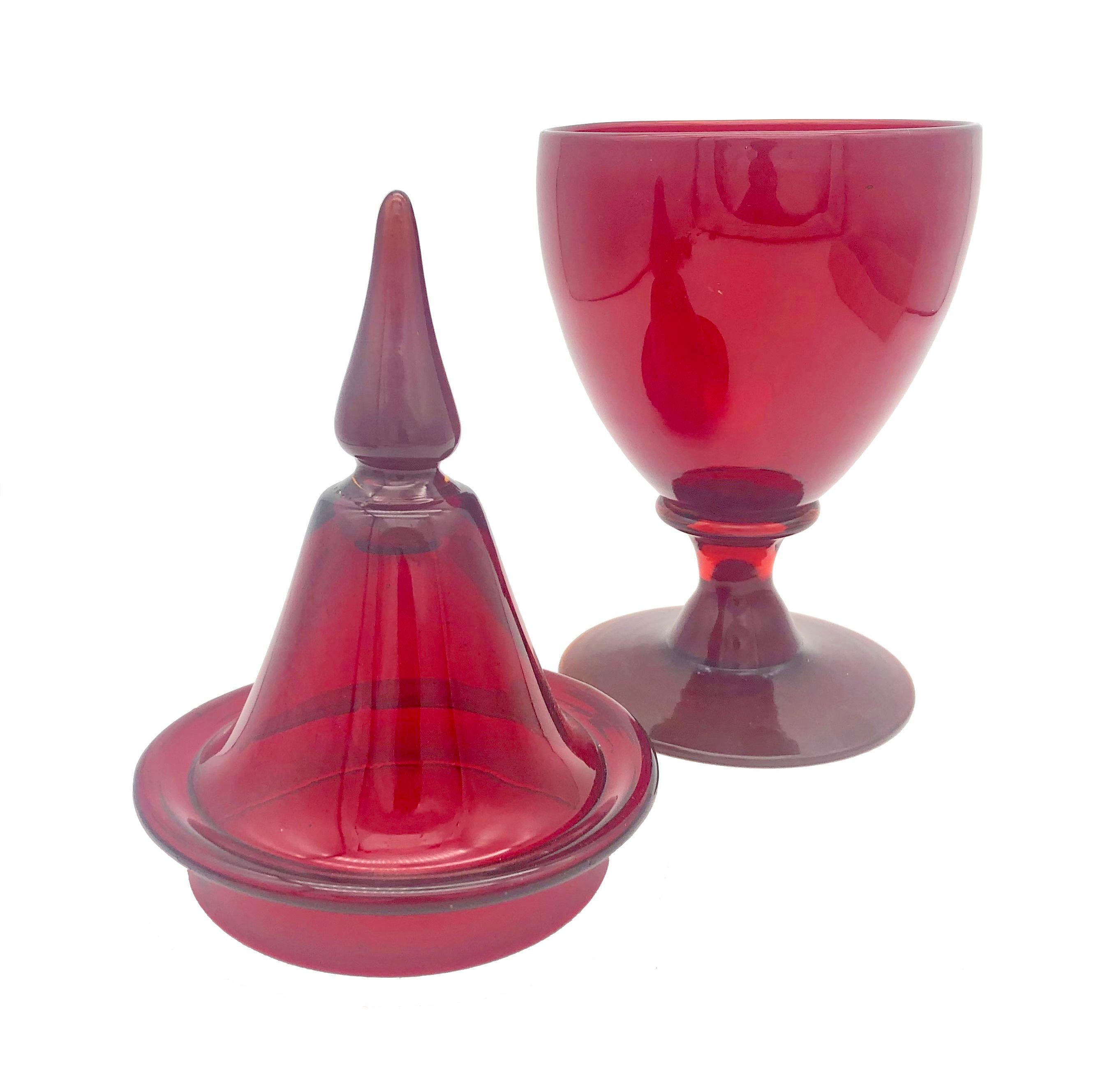 Dieses intensiv rote Glasgefäß mit seinem ornamentalen Deckel wurde Mitte des 20. Jahrhunderts in Frankreich mundgeblasen. Das fabelhafte Rot dieser eleganten Bonboniere verleiht jedem Tisch oder dekorativen Arrangement ein festliches Aussehen und