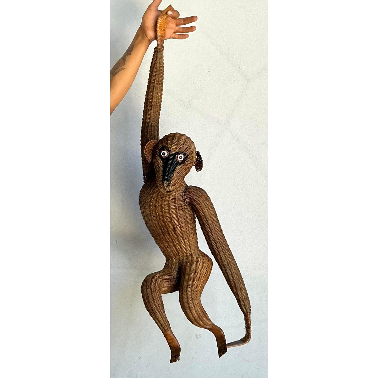 Inietta nella tua casa una deliziosa dose di fascino giocoso e di stravaganza di metà secolo con questa fantastica scultura vintage a forma di scimmia appesa. Questo primate di grandi dimensioni è magistralmente intrecciato a mano in ricco rattan
