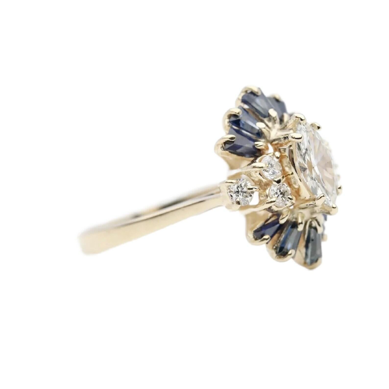 A vintage mid century marquise diamond and sapphire cocktail cluster ring in 14 karat yellow gold. Centering this unique ring is a 0.50 carat I color VS2 clarity marquise cut diamond. Framing the marquise diamond are six round diamonds weighing a