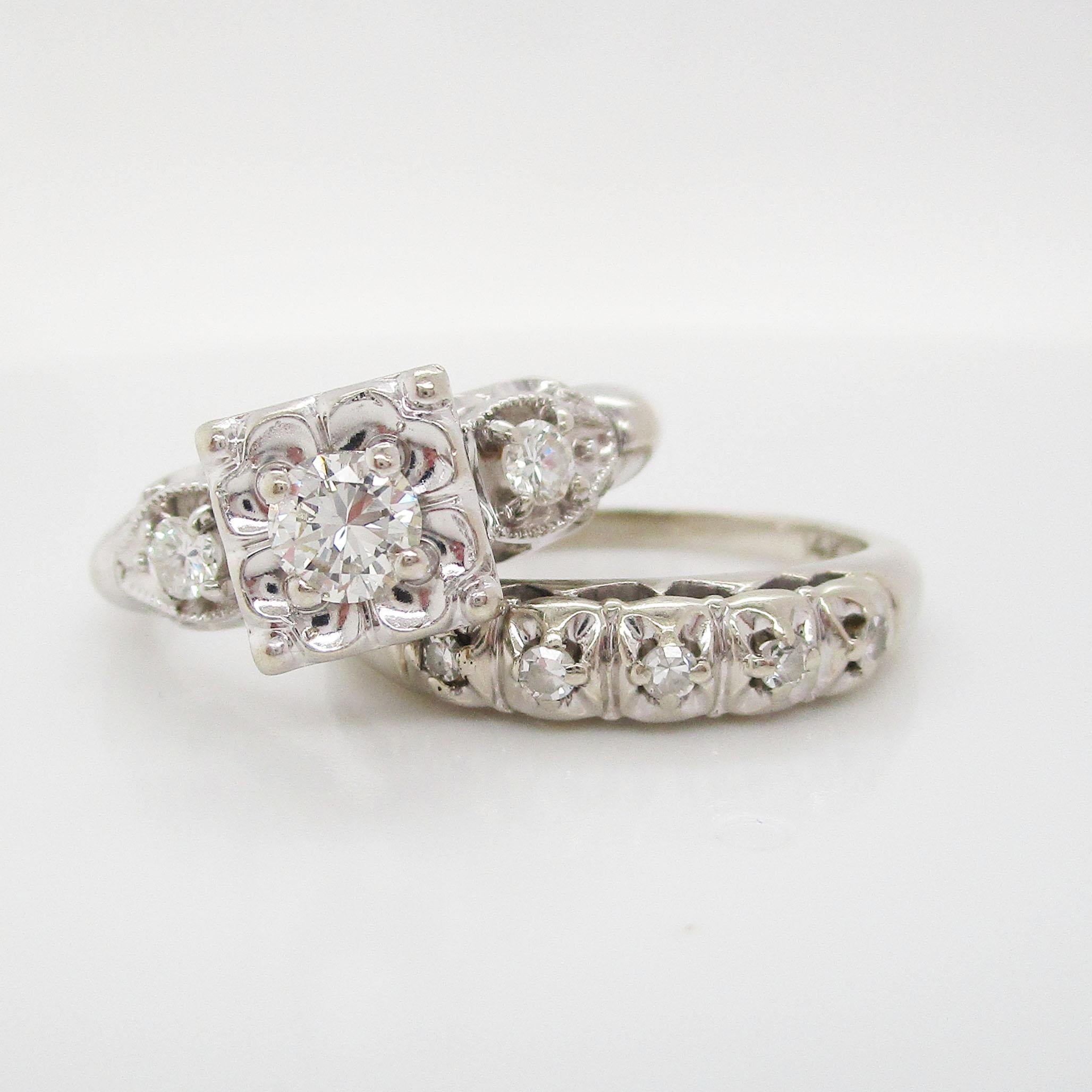 This is a truly gorgeous vintage diamond wedding set in 14k white gold with a beautiful mid-century design! The band is a classic five stone layout with a pierced under gallery detail. The band is lovely enough to be worn on its own by the busy