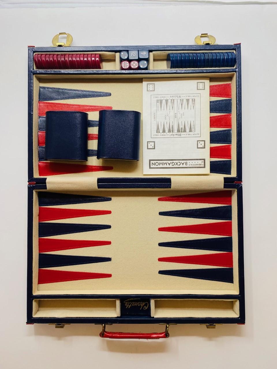 Vintage 1960s backgammon set. This set is Classic. Enveloped in blue with red trimming and with brass detailing, the set opens to a playful design is complete with 2 sets of stones, dice. Compact and original. Easy to carry and store. Minimal style