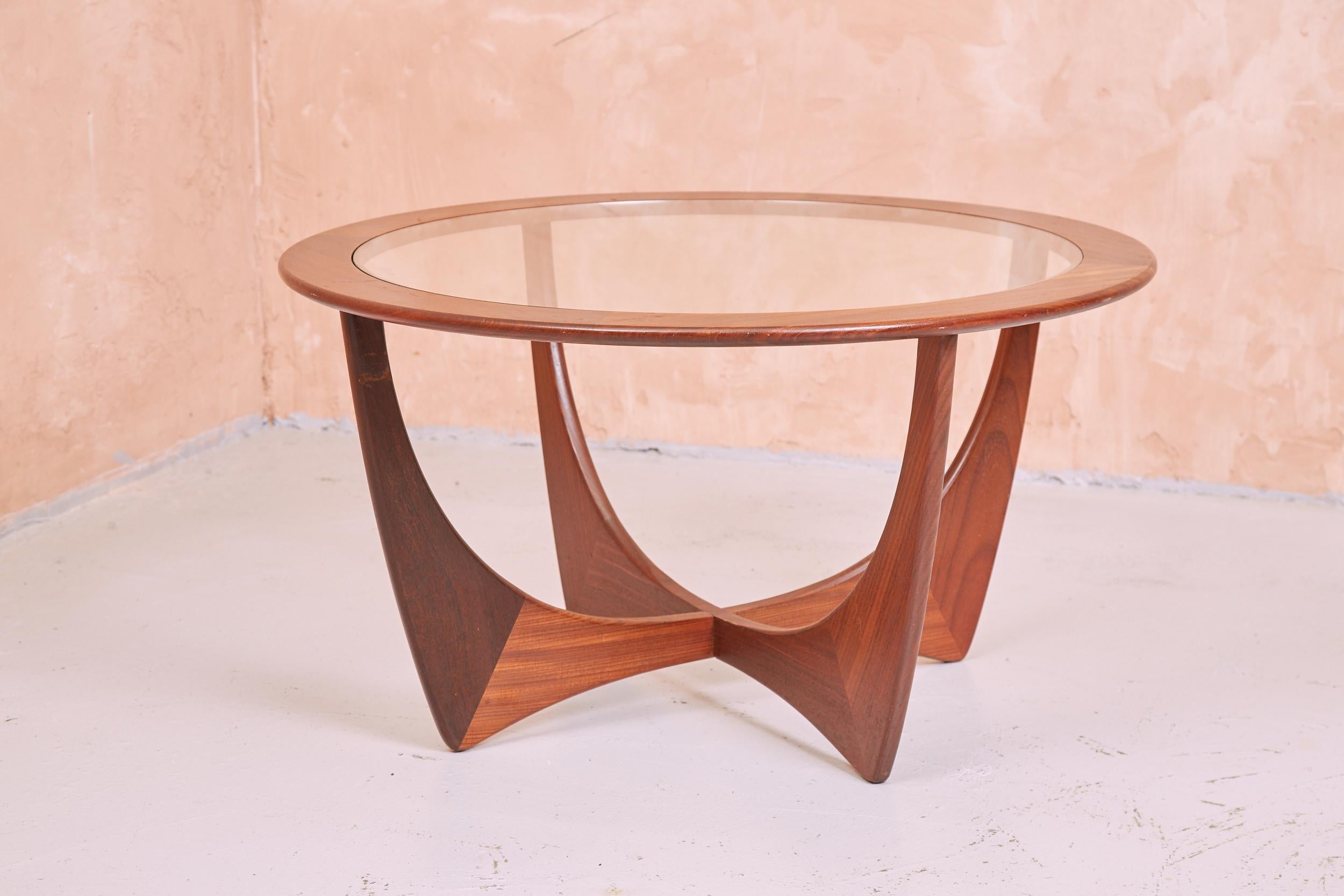 A vintage G Plan Astro table. A quintessential staple of a British mid century interior. A glass top inlaid in a circular teak frame, supported by the iconic teak astro legs.