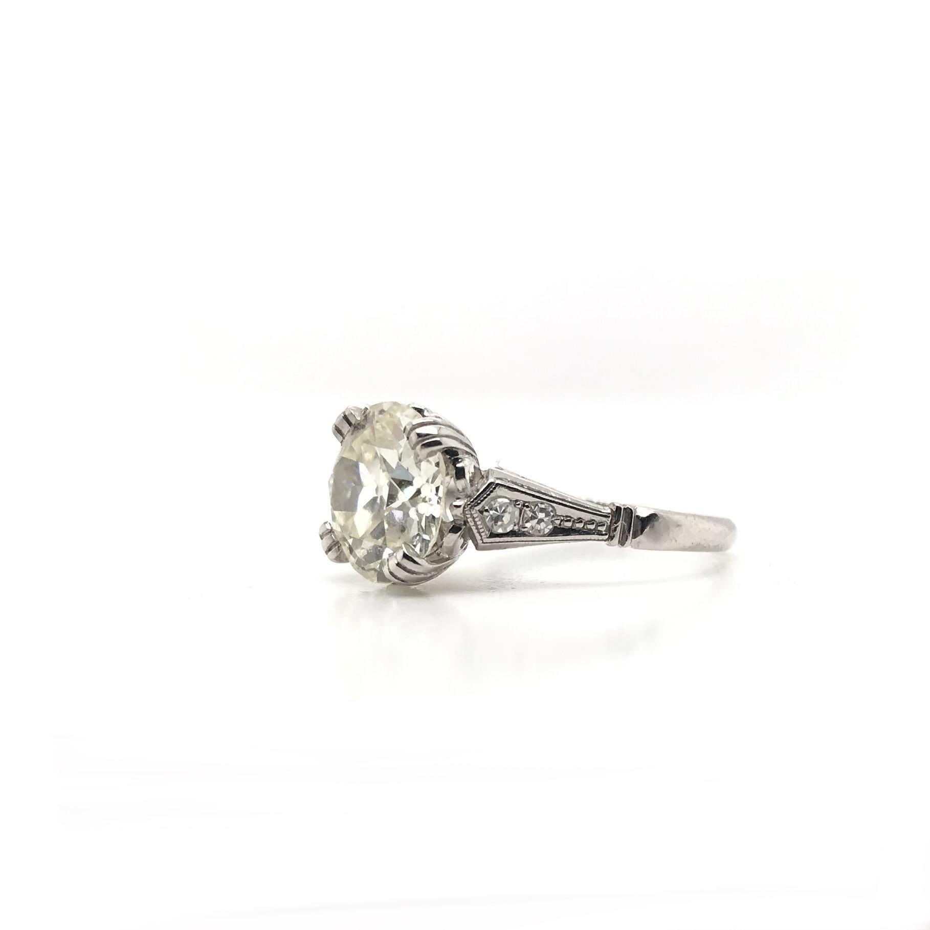 This stunning vintage piece was crafted sometime during the Mid Century design period (1940-1960). The platinum setting features a center diamond measuring approximately 2.41 carats. The center diamond has been certified by the Gemological Institute