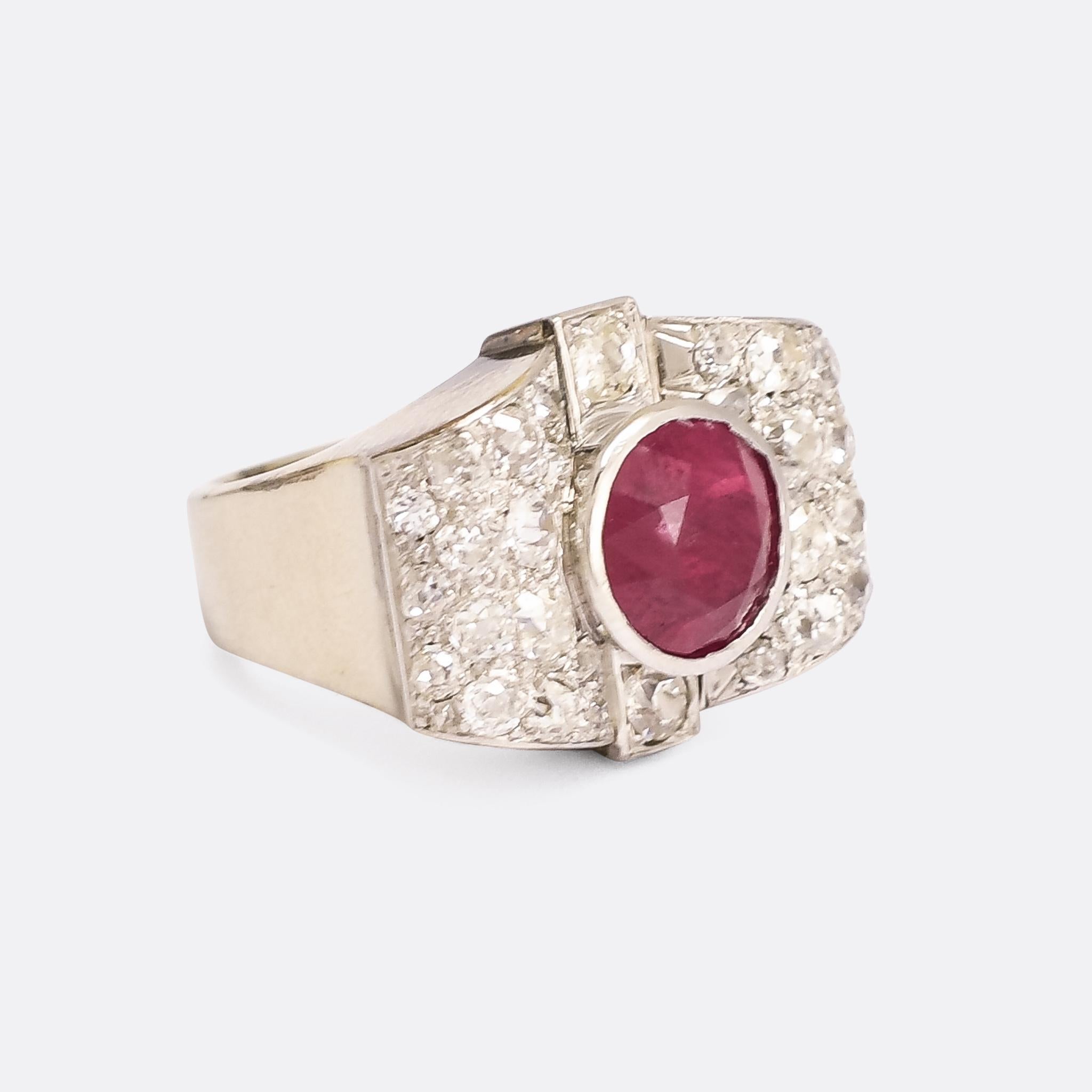 An incredible modernist cocktail ring dating from the 1950s. The principal stone is a mouthwatering 4.77 carat no heat Burma ruby, bezel set within two waves of pavé old mine cut diamonds. It's crafted in platinum throughout, with French hallmarks