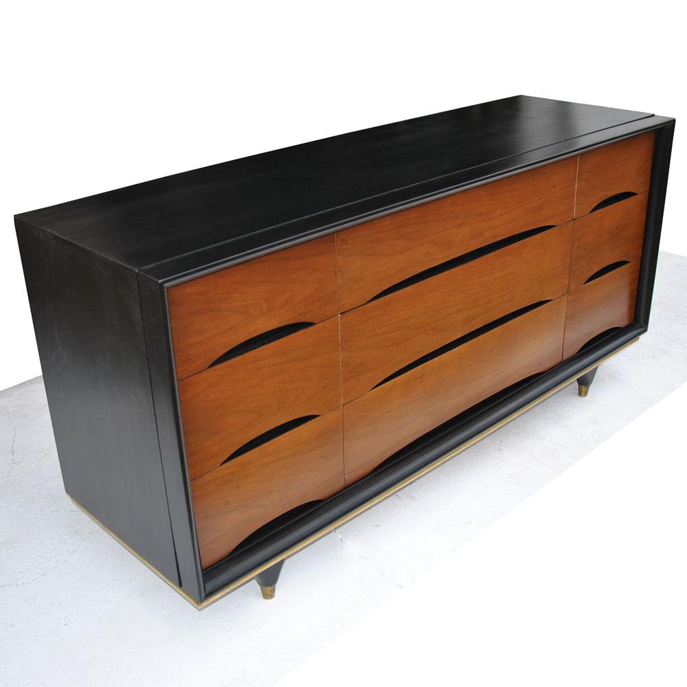 5ft Kent Coffey Elegante 9 Drawer Dresser 


This 1960s Kent Coffey walnut dresser from the Elegante furniture line features nine drawers. Contrasting ebonized top, sides and front panels highlight the rich walnut grain. Brass feet and trim.
