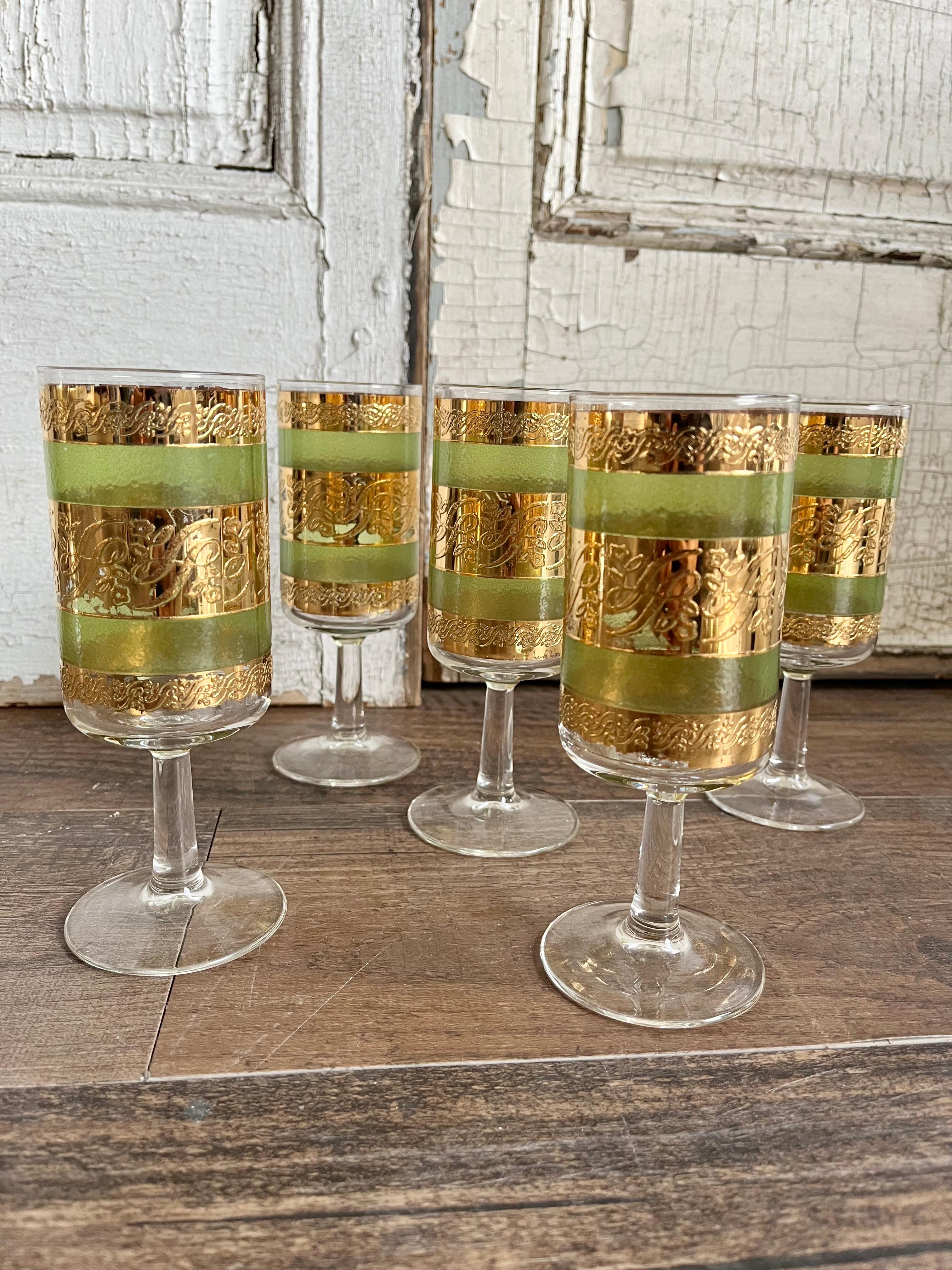 This set of 5 cocktail glasses is a true gem from the 1960s era, featuring a stunning combination of green glass and 22K gold stems that create a unique and elegant look. The glasses are made by Culver, a company known for producing high-quality