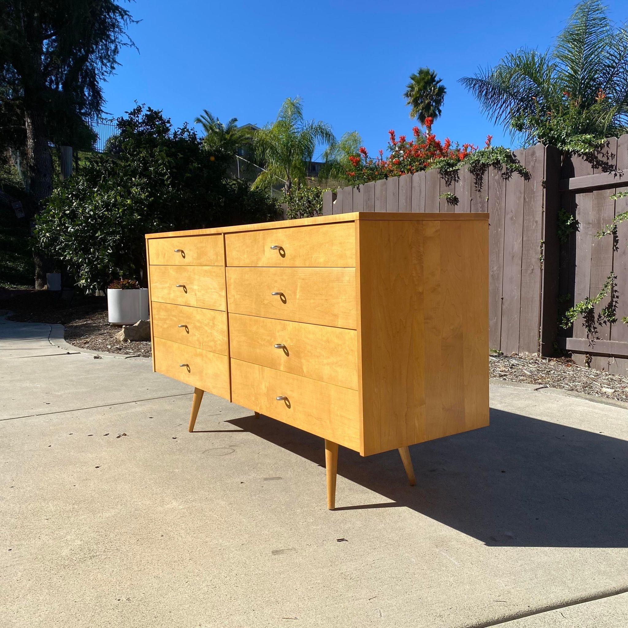 Now available is an amazing 8 drawer dresser designed by Paul McCobb for Planner Group, labeled. Features aluminum pulls, classic tapered legs for that sleek mid century look, and a solid maple finish. Although this piece has some wear, it is