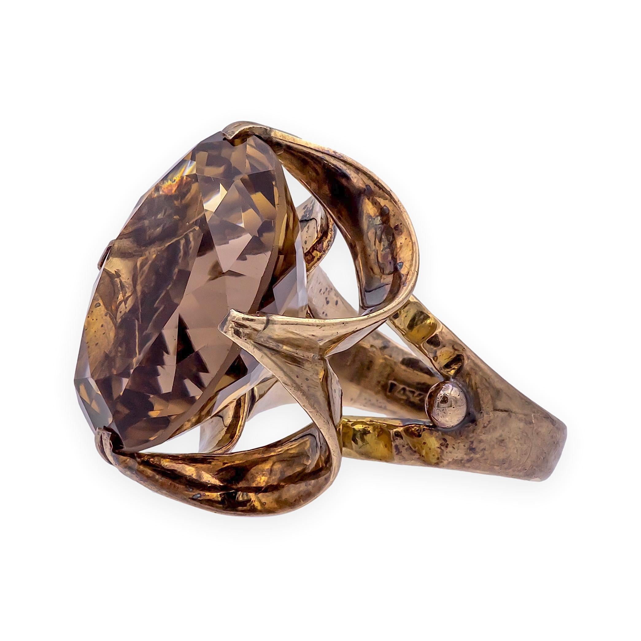 Ein kühner Statement-Ring aus der Mitte des Jahrhunderts mit einem großen Rauchquarz in einer architektonischen Goldfassung mit offenem Rahmen. Das Design spiegelt die skulpturale Ästhetik der 1960er bis 1970er Jahre wider, in denen übergroße