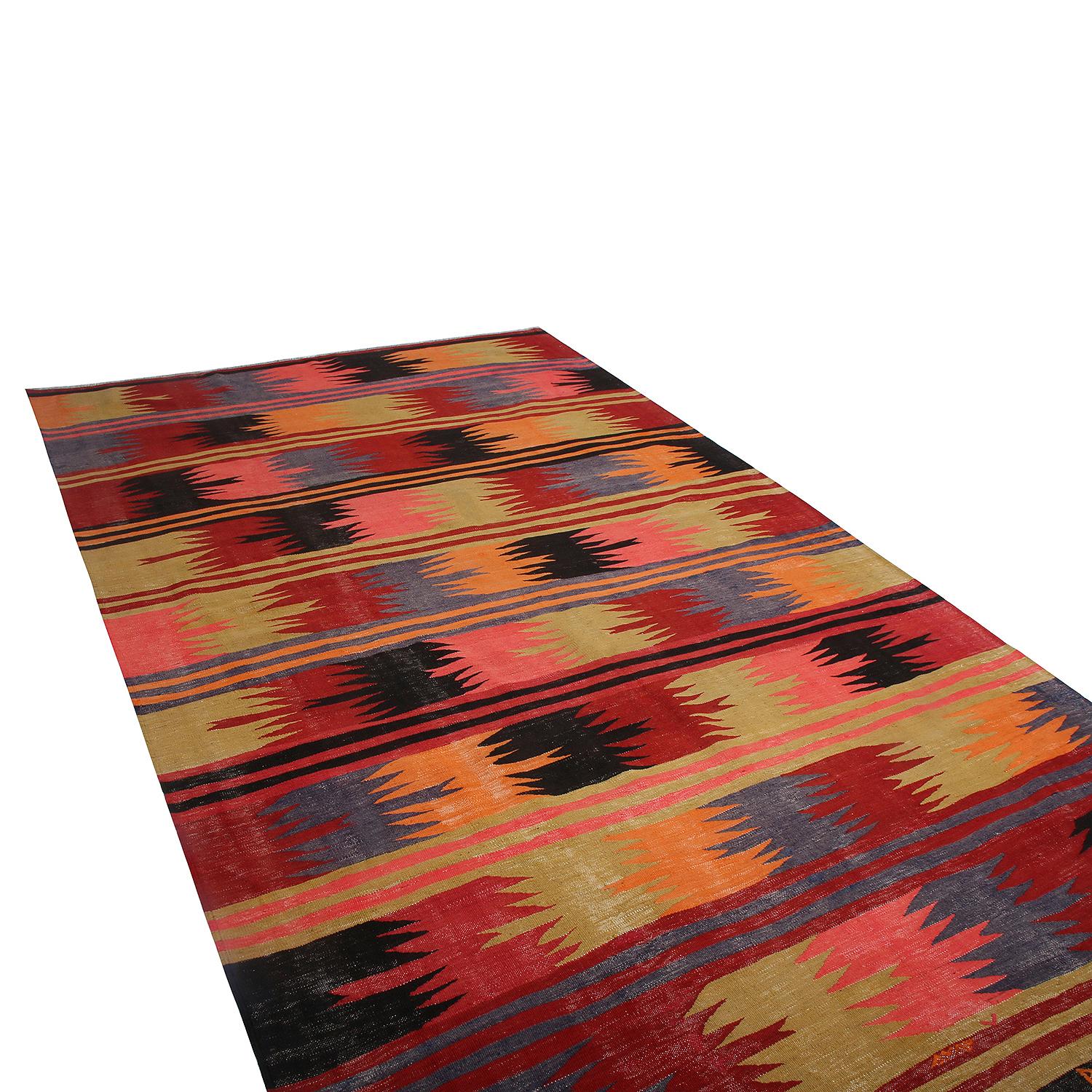 handwoven in Turkey originating between 1950-1960, this vintage mid-century wool Kilim hails from the Afyon province, presenting a bold multi-color pallet of tribal blue, red, green, pink, orange and blue complementing the meticulous geometric