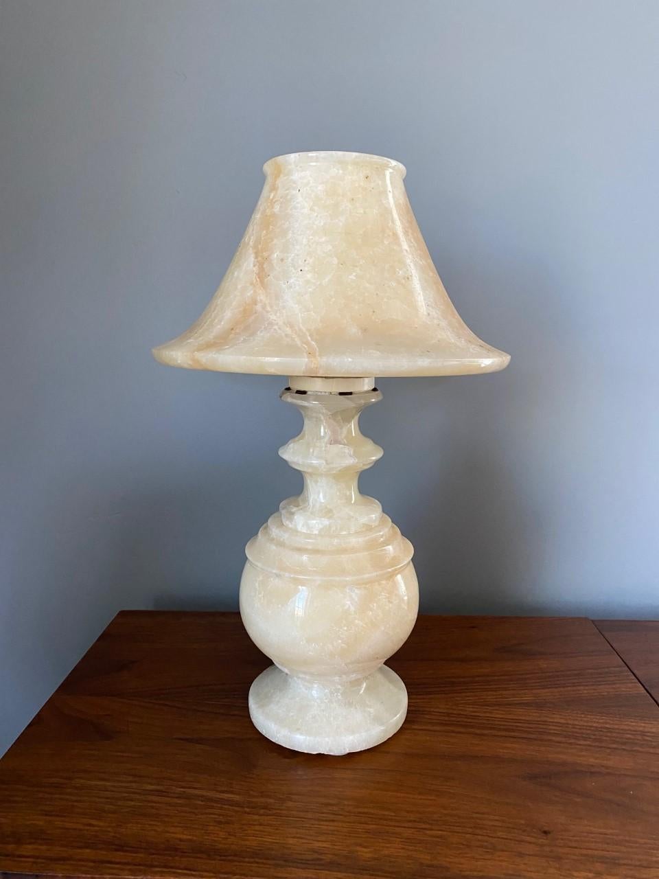 Beautifully carved alabaster marble lamp that is striking and beautiful. This lamp is composed of a marble body and a marble shade and together stand not only as a lamp, but as a sculpture. The classic shapes against the translucent alabaster give