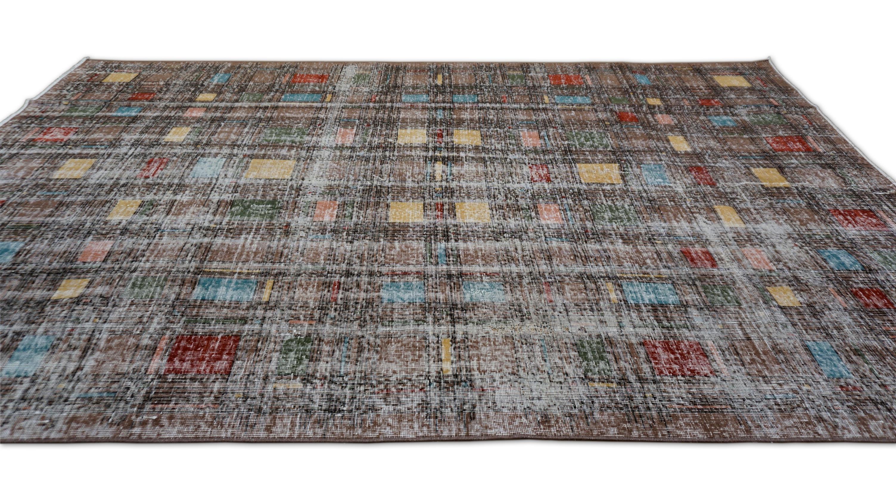 This hand-knotted wool rug presents a sophisticated reinterpretation of mid-century modern grid patterns, softened through a vintage wash and distressed texture. Set against a subdued Brown base, the composition is punctuated with understated blocks