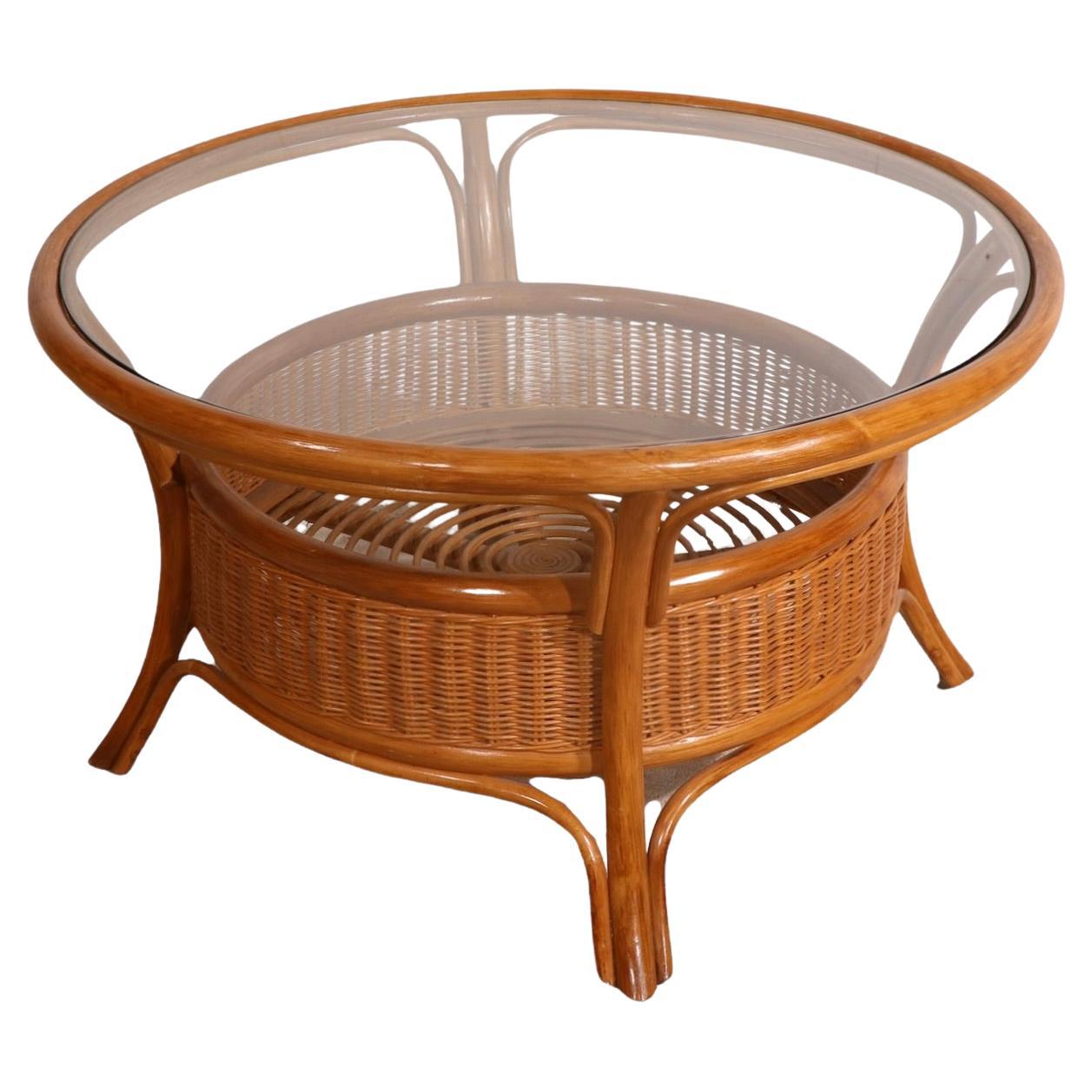 Elegant and casual style coffee table, in excellent original condition, clean and ready to use. The table has its original glass top, which rests in place on the bamboo and wicker base. Nicely executed and well detailed table, in very fine