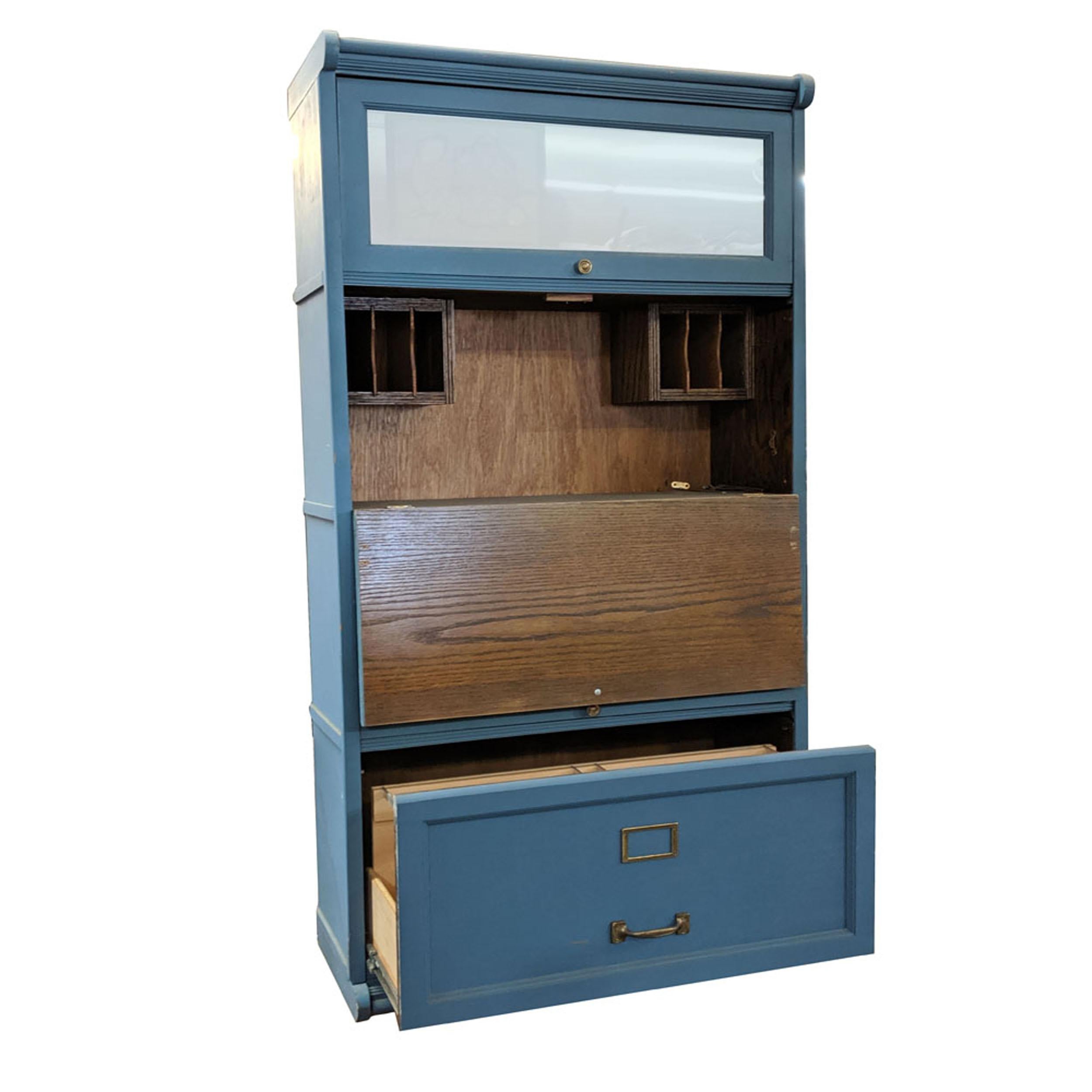 Vintage mid century barrister multi function bookcase file cabinet

Unusual version of a barrister bookcase.
Antique blue with file drawer, secretary work space and book storage.