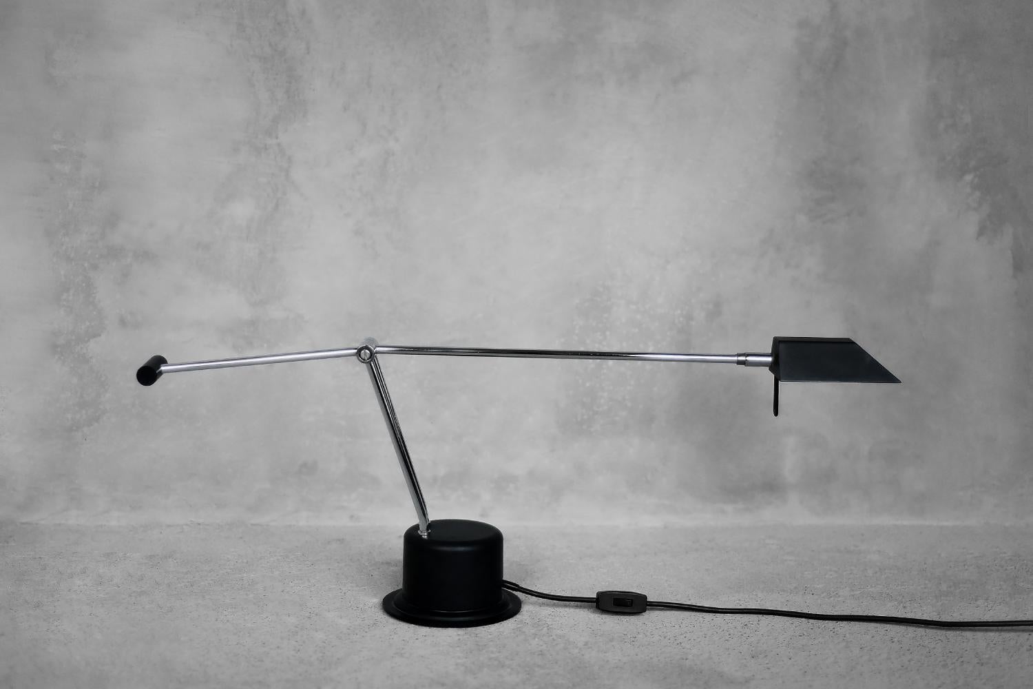 This minimalist desk lamp was produced by the Belgian manufacturer Massive during the 1980s. The movable arm is made of chrome-plated steel, and the base and lampshade are made of high-quality black plastic. The arm and shade can be adjusted to