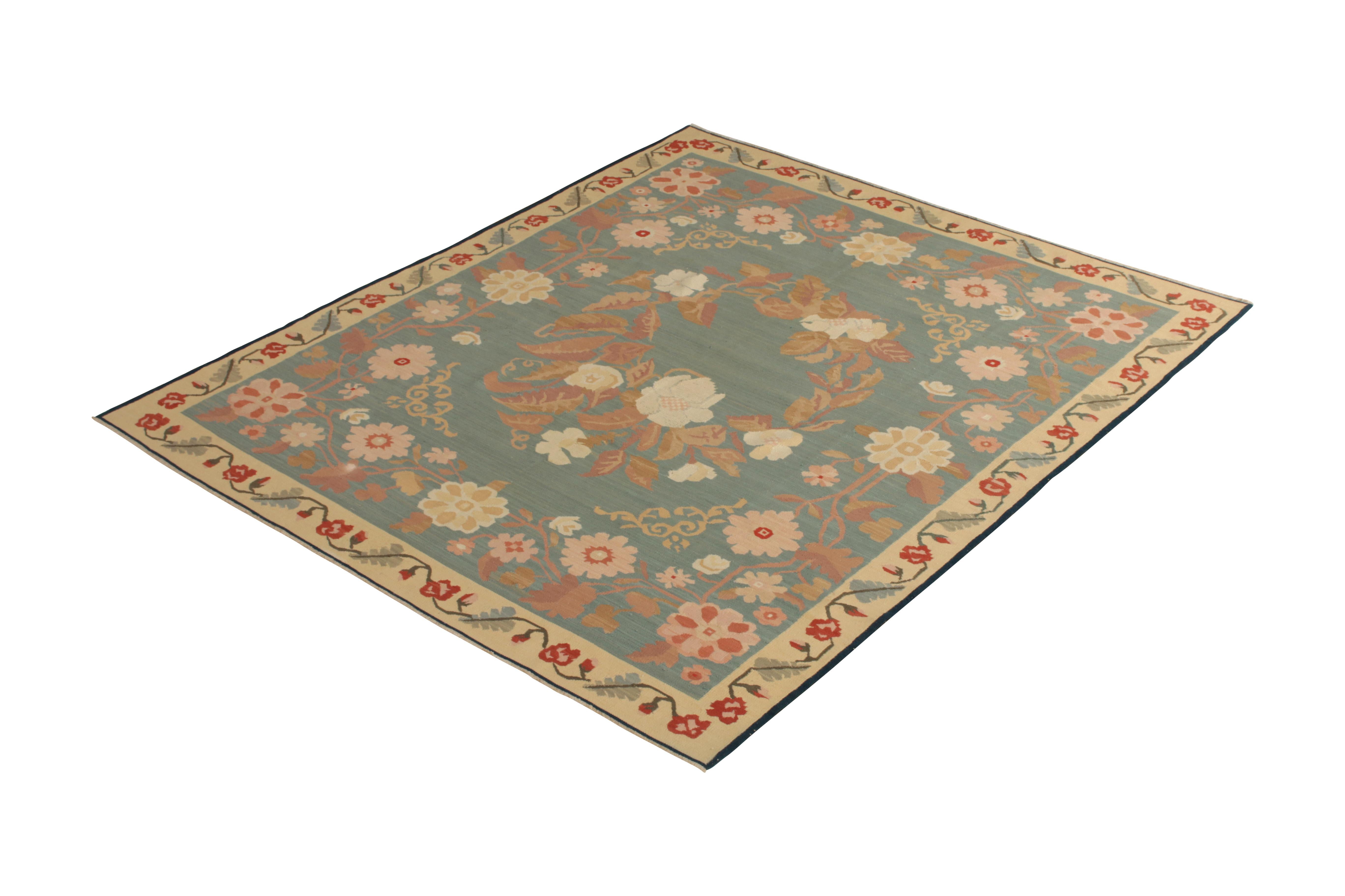 Handmade in flat-woven wool originating from Turkey circa 1950-1960, this midcentury rug is a unique vintage Bessarabian Kilim of notably forgiving color, employing a medallion style pattern and unique floral imagery in complementary hues of blue