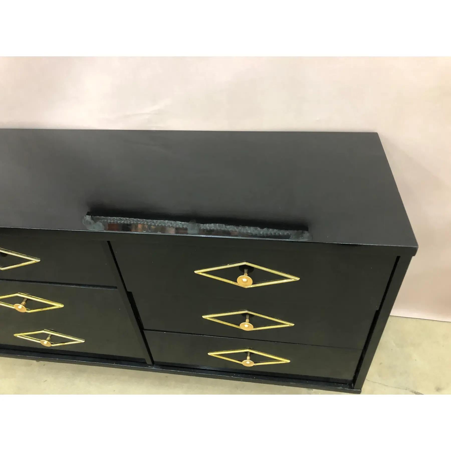 Cassapanca di metà secolo in lacca nera. La struttura è a sei cassetti e ogni cassetto è decorato con un'applicazione metallica a forma di diamante. La cassapanca poggia su gambe affusolate in argento dorato. 
Per favore, contattaci per conoscere le