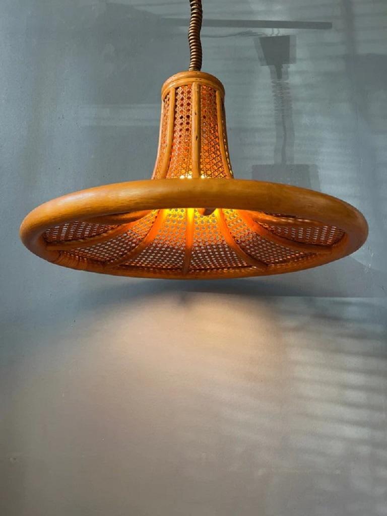 A big mid century bamboo pendant lamp. The 'boho' style light fixture has a nice decorative pattern through which the light escapes. The height of the lamp can easily be adjusted with the rise-and-fall system. The lamp requires one E27/26