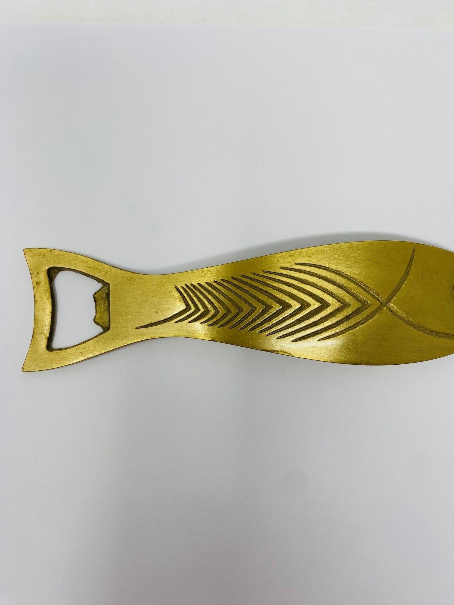 Beautiful vintage brass bottle opener.  This beautiful vintage novelty is sculpted as a fish with great detailing and luxurious lines.  Created in brass, this piece shines in exuberance.  Detailed carving and semi precious stones give it shape and